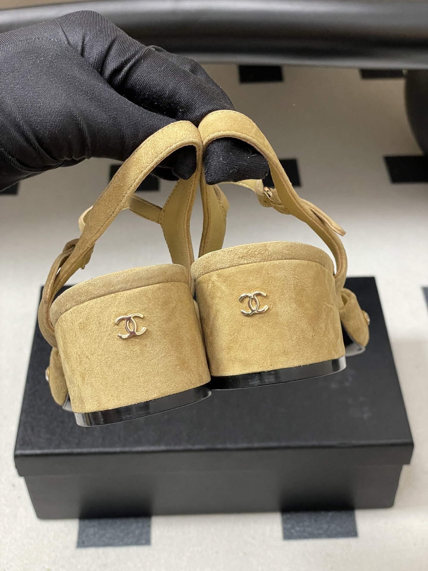 Pair of Chanel beige suede slingback pumps with black cap toes and crystal studs on a black surface - Hình 7