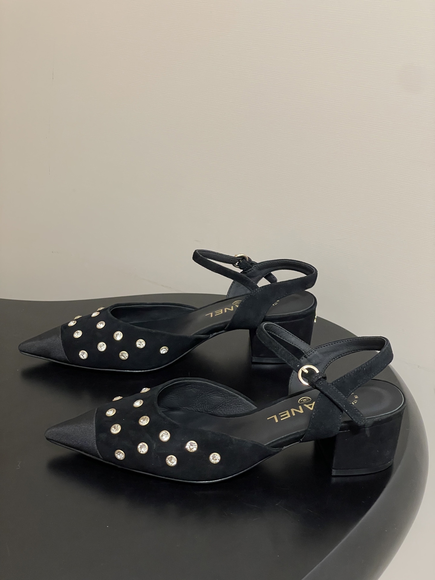 Chanel black suede slingback pumps with crystal embellishments and low block heels displayed on a black surface - Hình 3