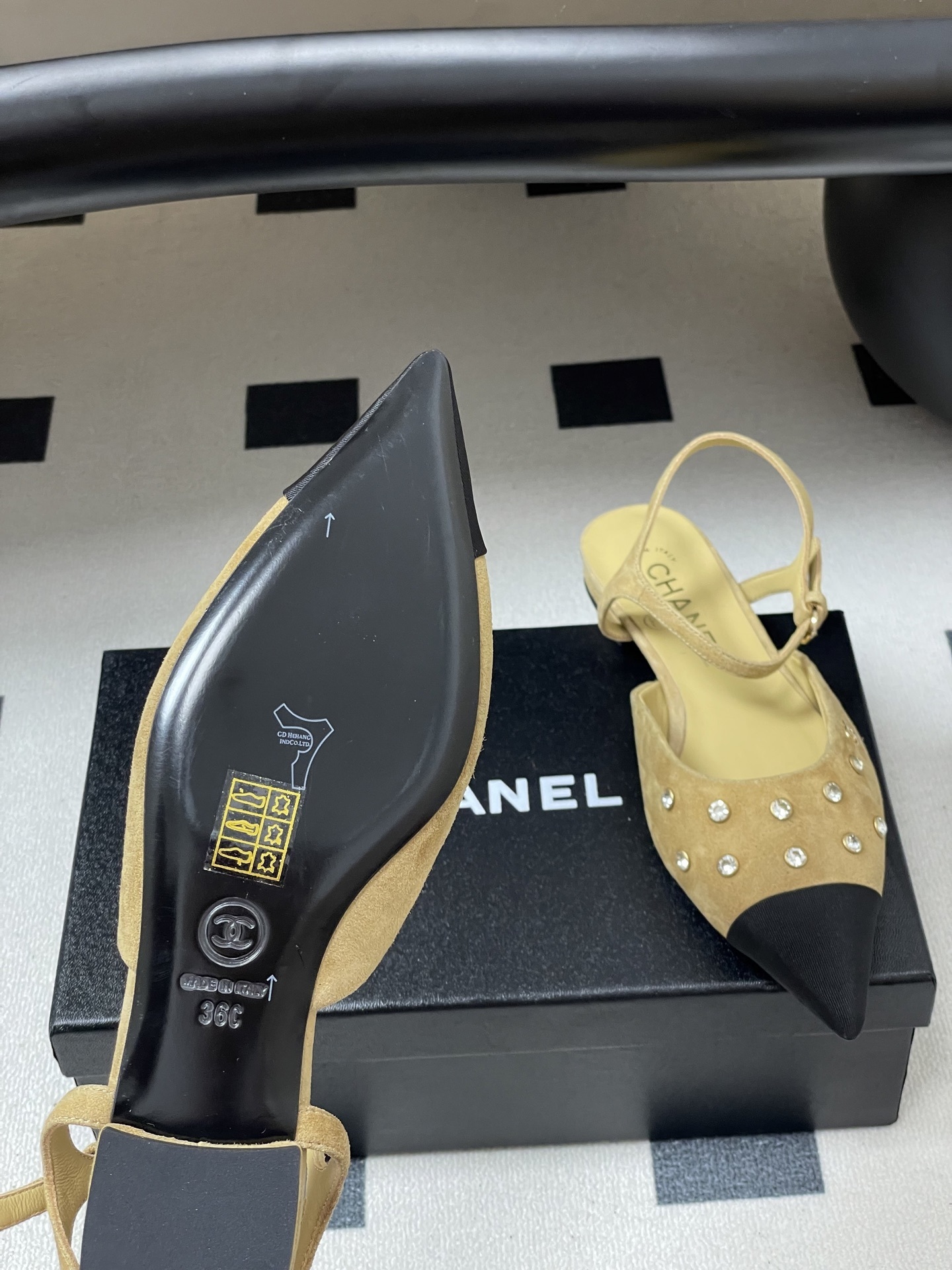 Luxury Chanel slingback flats in beige suede with crystal accents and black pointed toes on a black table. - Hình 8