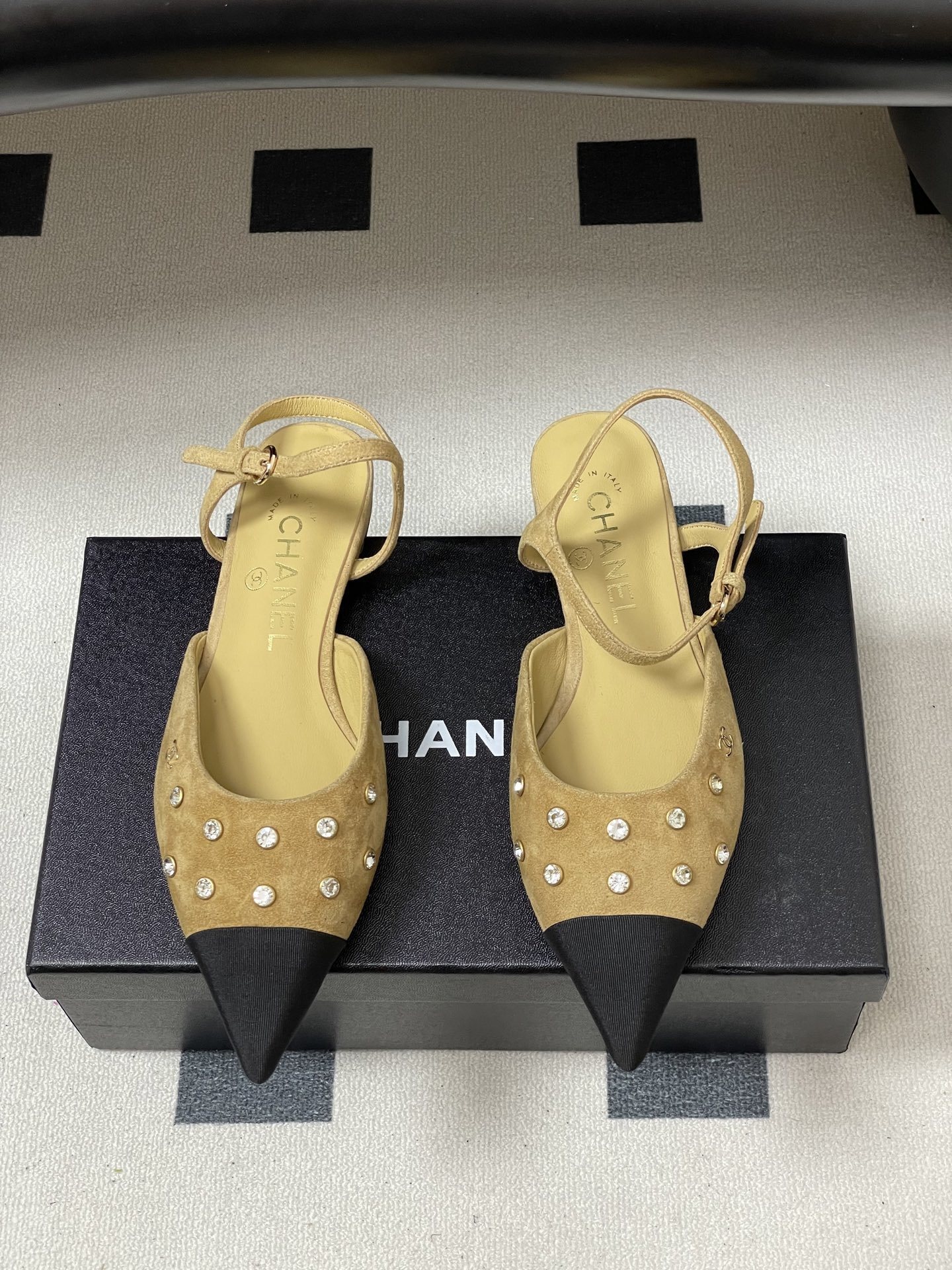 Luxury Chanel slingback flats in beige suede with crystal accents and black pointed toes on a black table. - Hình 5