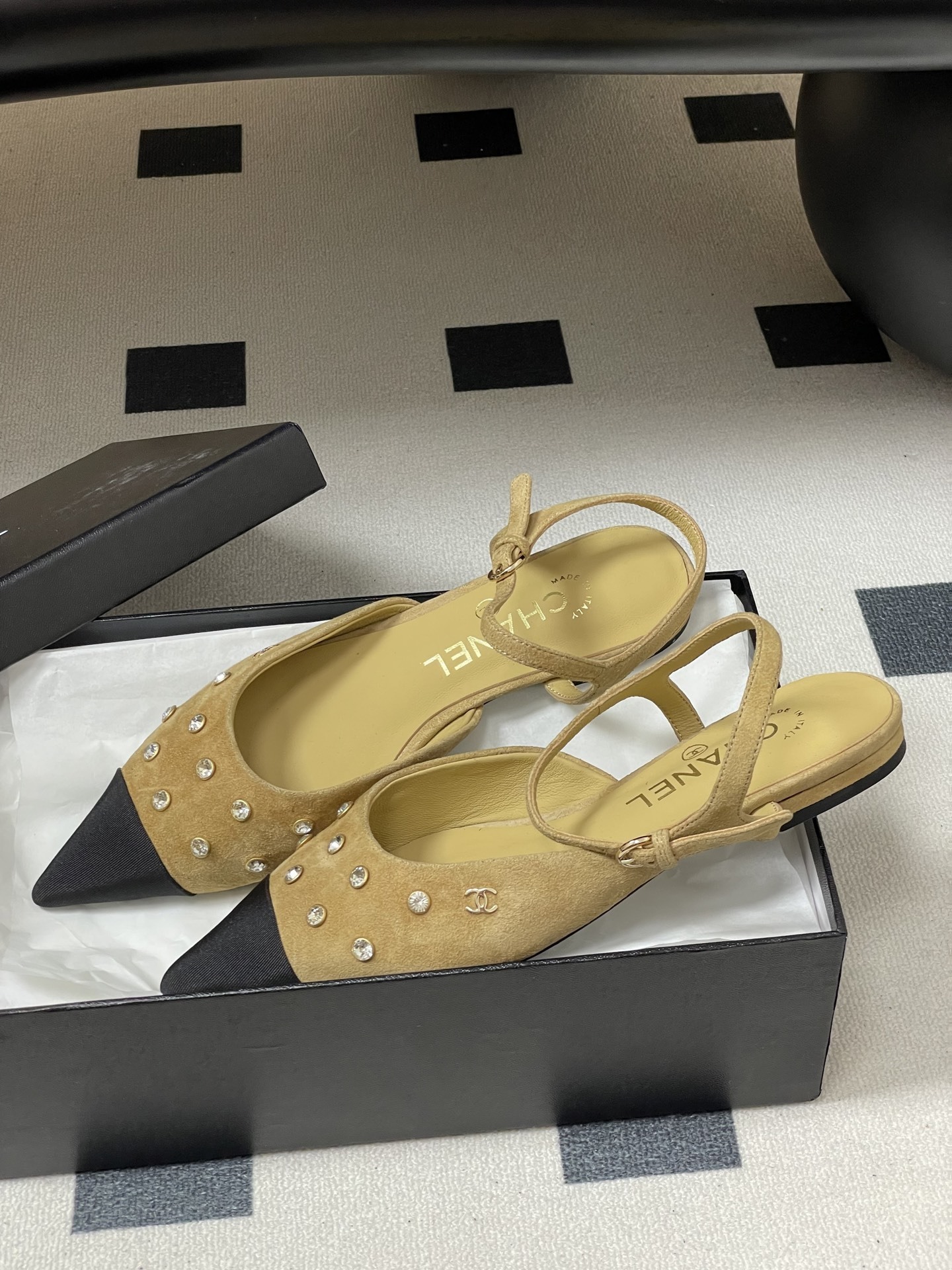 Luxury Chanel slingback flats in beige suede with crystal accents and black pointed toes on a black table. - Hình 4