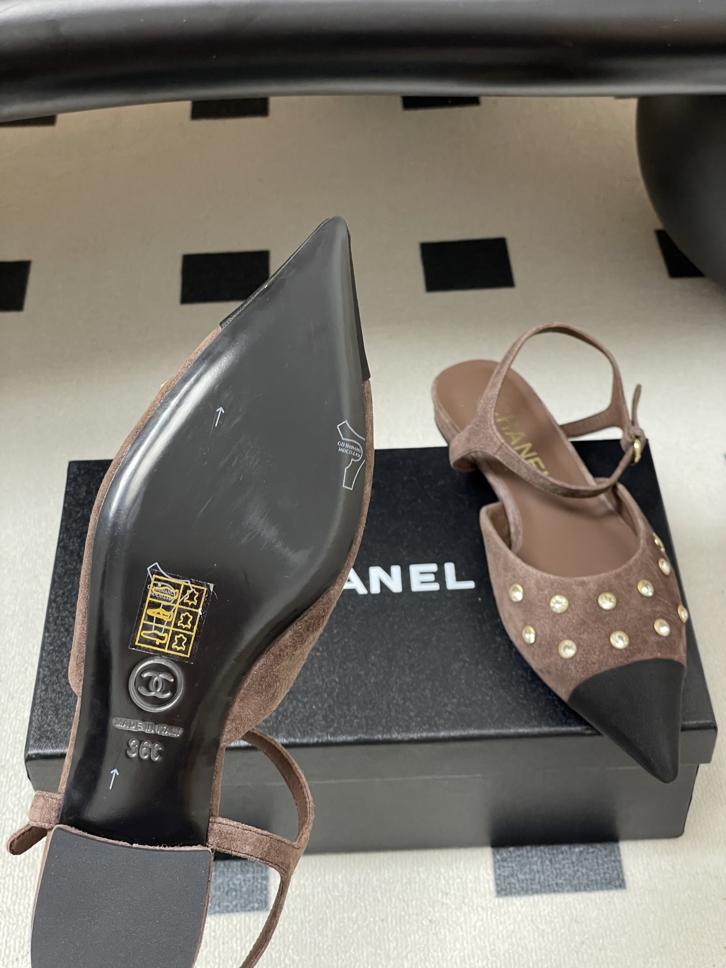 Pair of Chanel brown suede slingback flats with black pointed toes and crystal embellishments on a black table. - Hình 8