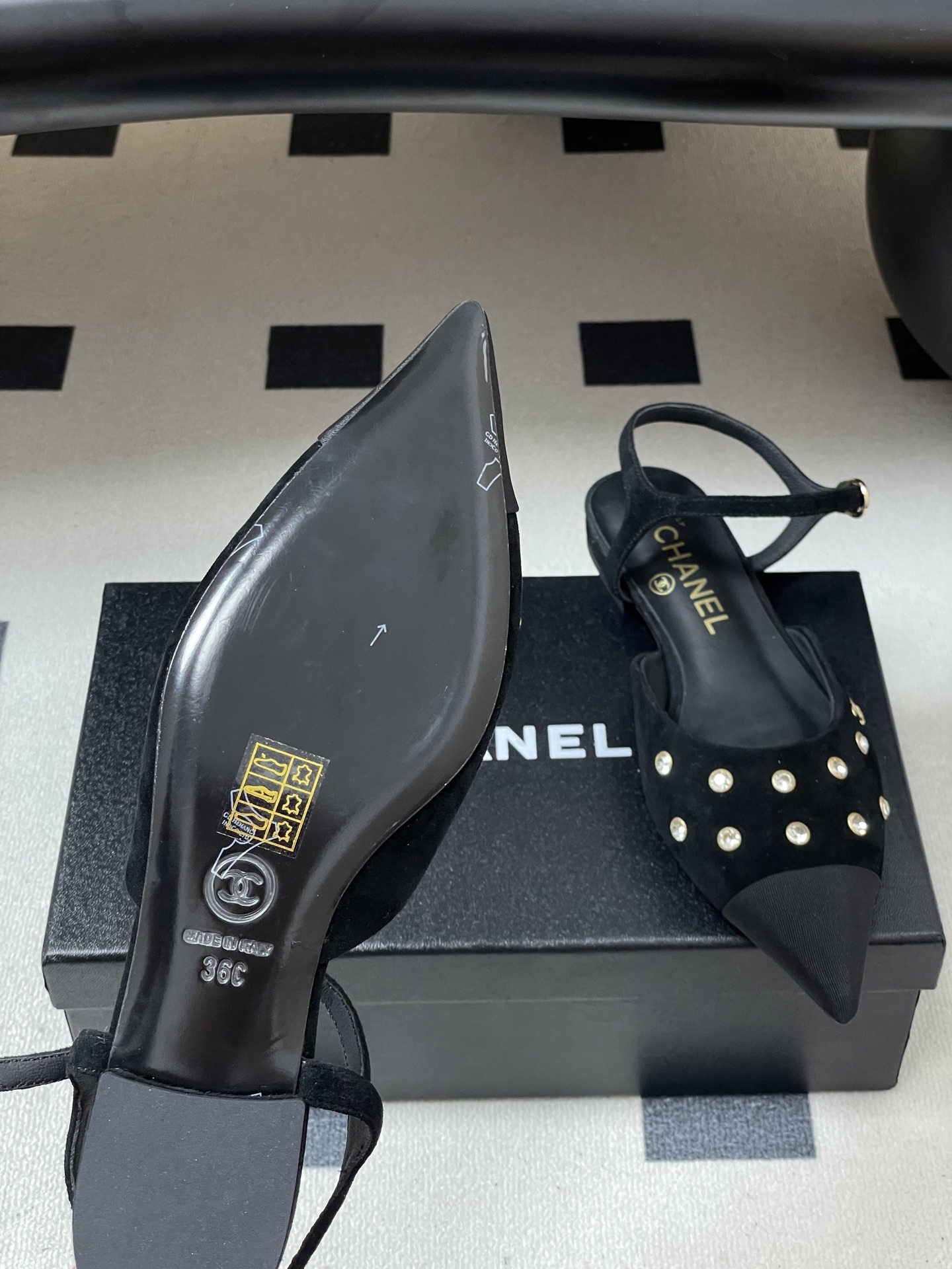 Chanel black suede pointed-toe slingback flats with crystal embellishments and gold CC logo on a black surface - Hình 8