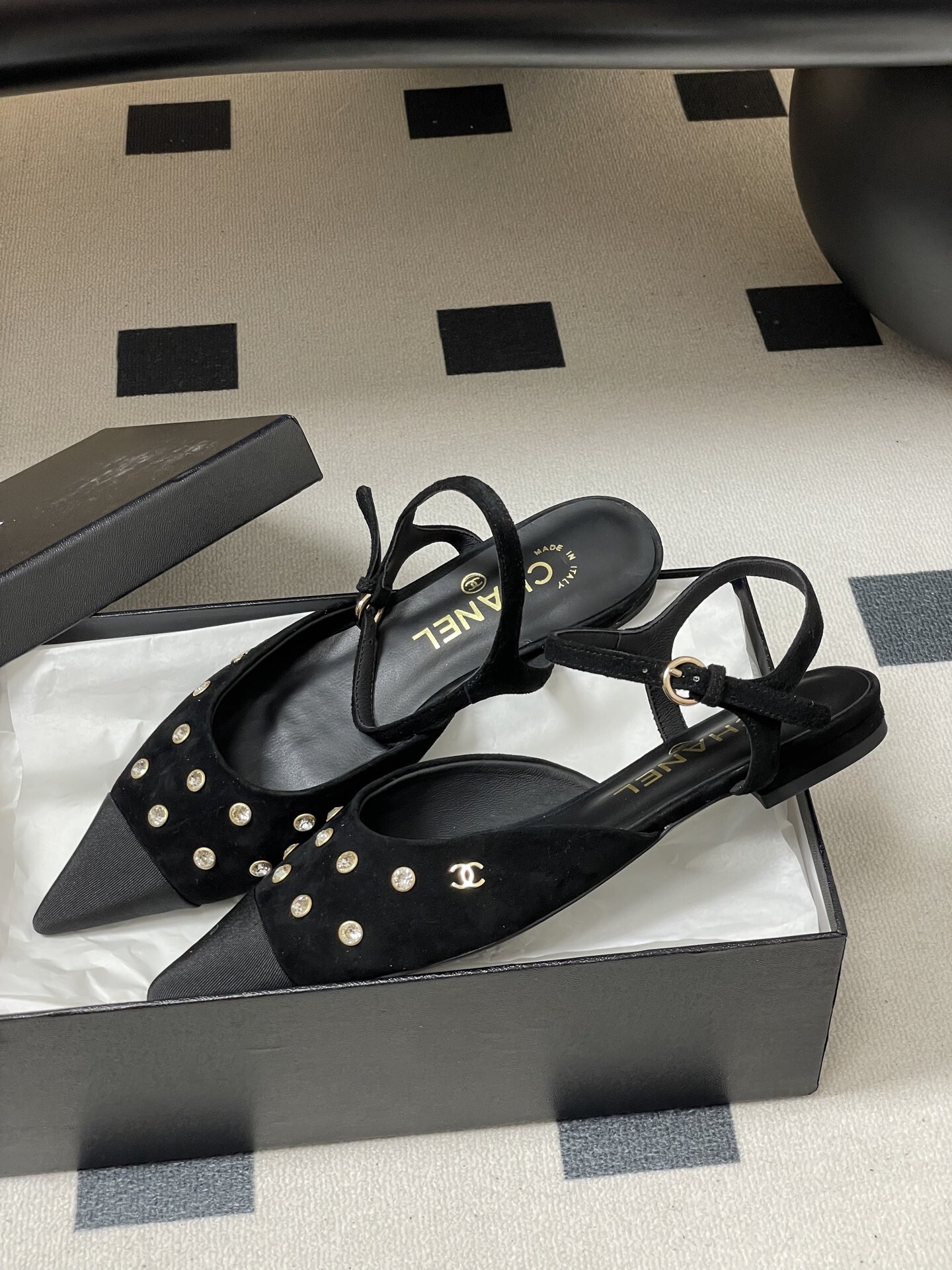 Chanel black suede pointed-toe slingback flats with crystal embellishments and gold CC logo on a black surface - Hình 4