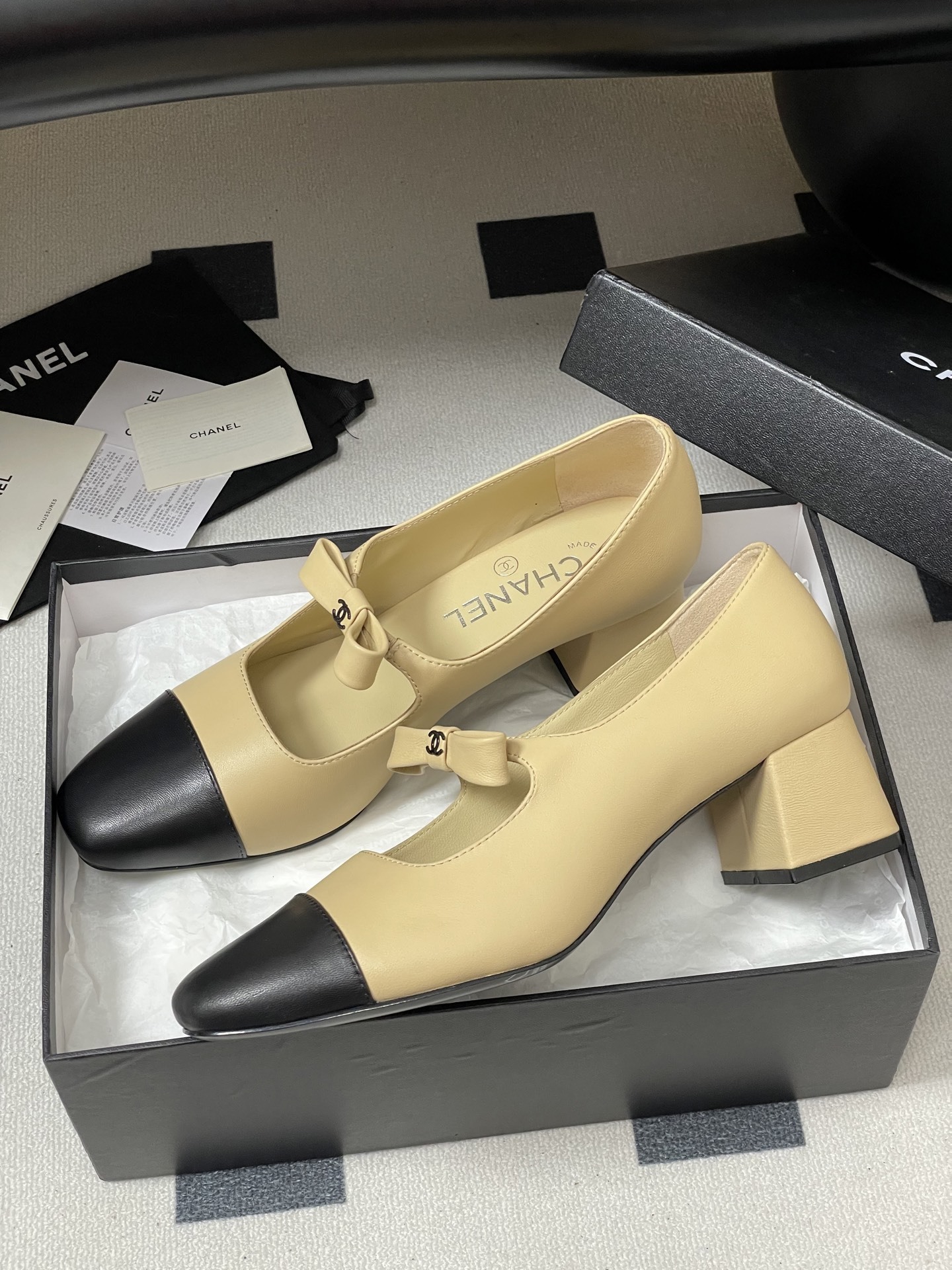 A pair of luxury Chanel beige leather Mary Jane pumps with black toe caps and CC logo bow details. - Hình 4