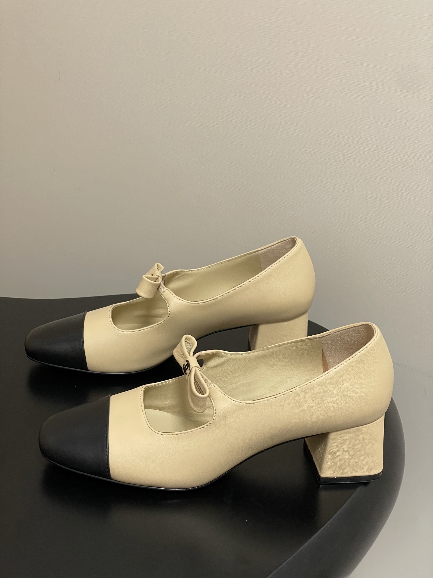 A pair of luxury Chanel beige leather Mary Jane pumps with black toe caps and CC logo bow details. - Hình 3