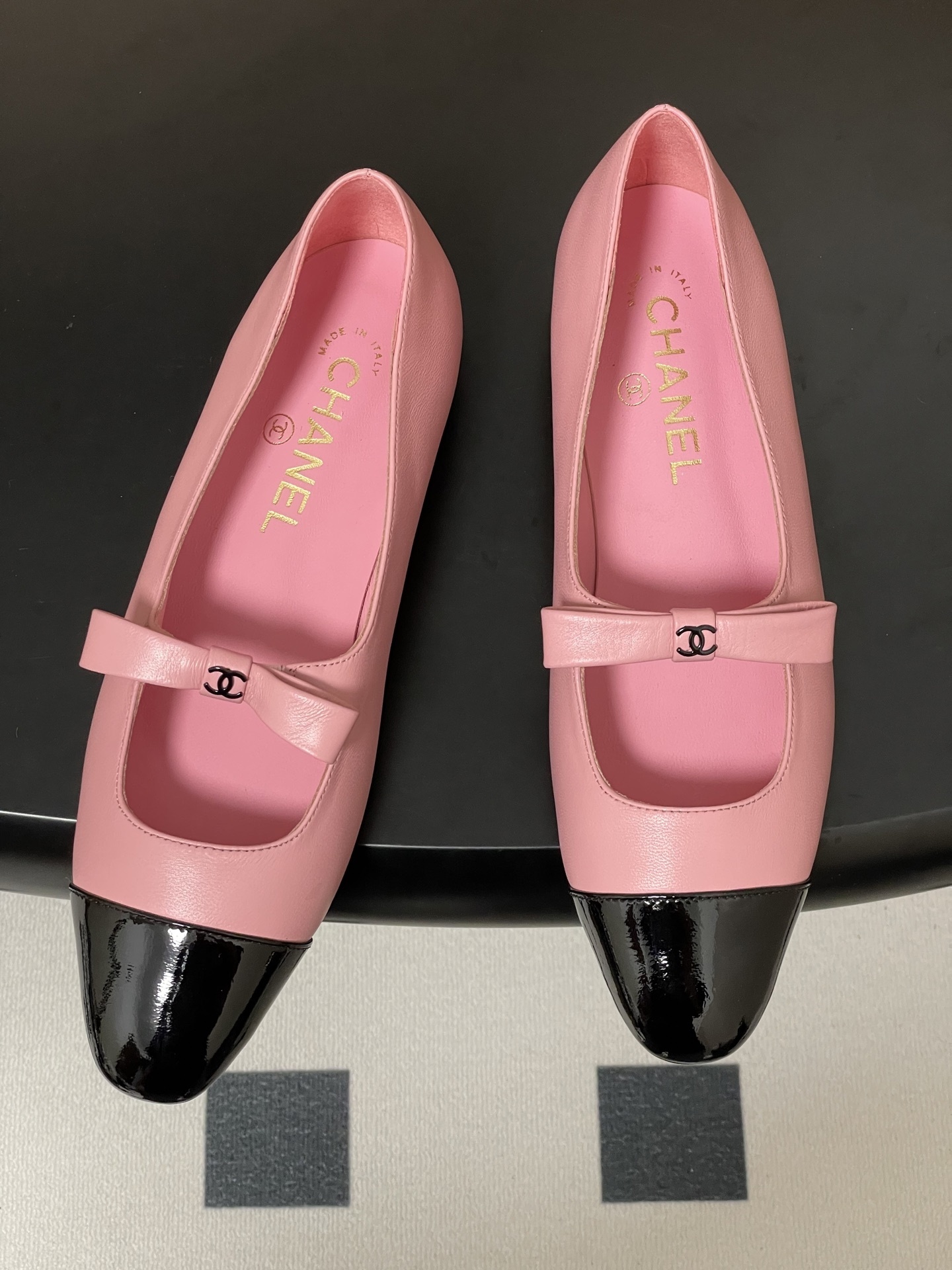 A pair of luxury Chanel pink leather Mary Jane ballet flats featuring black patent leather cap toes and CC logo bow straps. - Hình 2