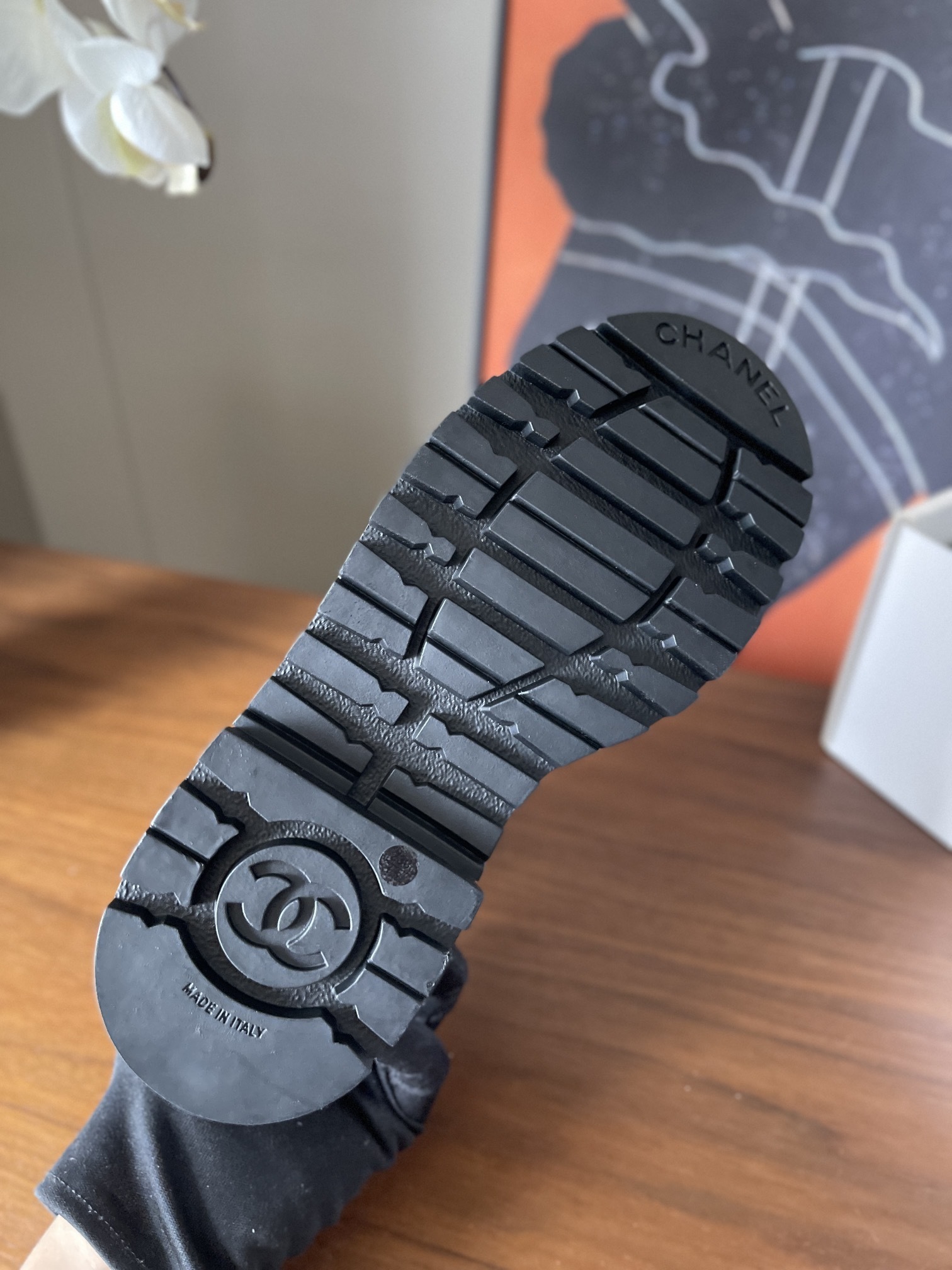 A pair of black Chanel grained leather combat boots with chunky platform soles and gold lettering on the tongue. - Hình 8