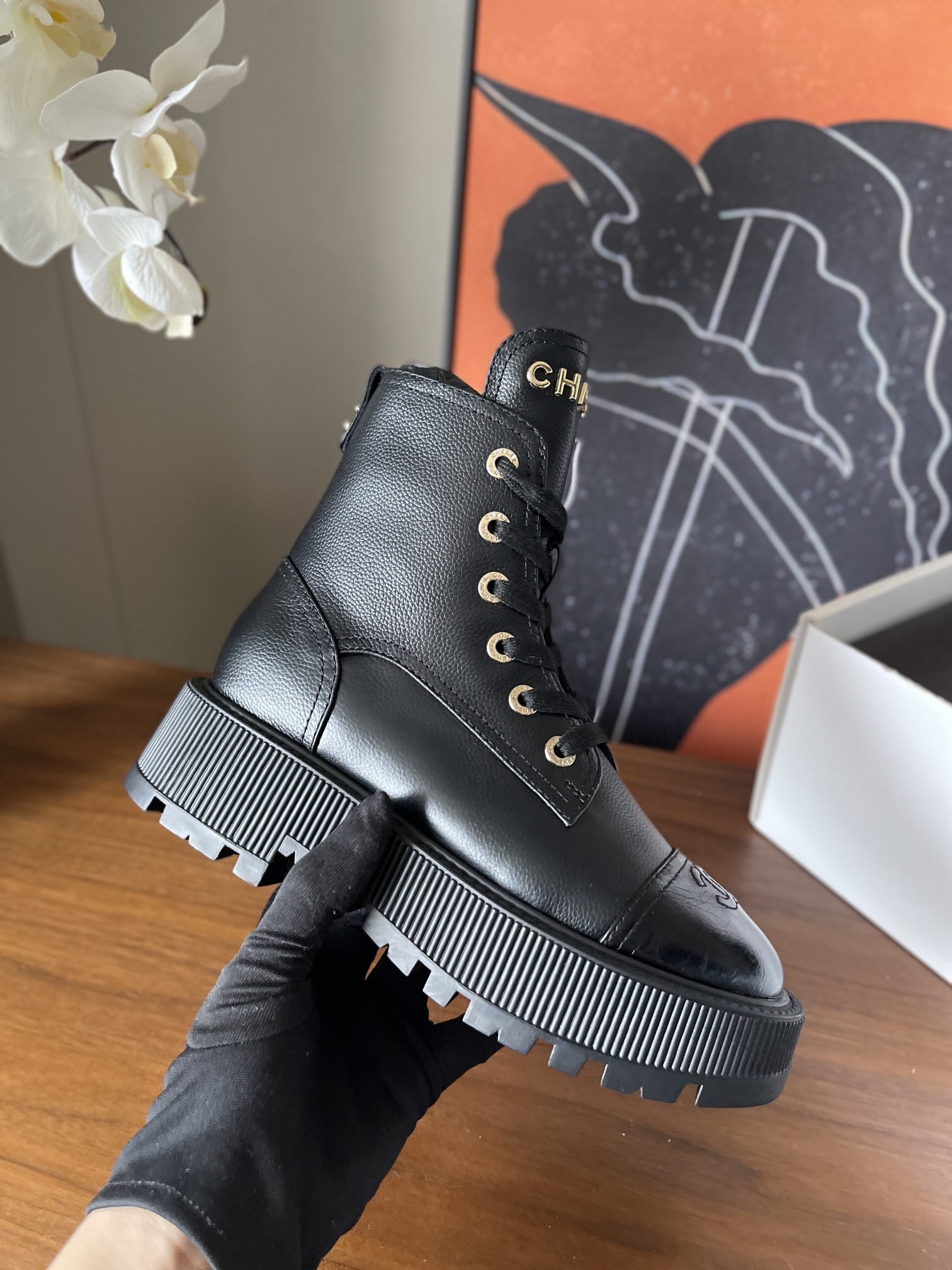 A pair of black Chanel grained leather combat boots with chunky platform soles and gold lettering on the tongue. - Hình 5