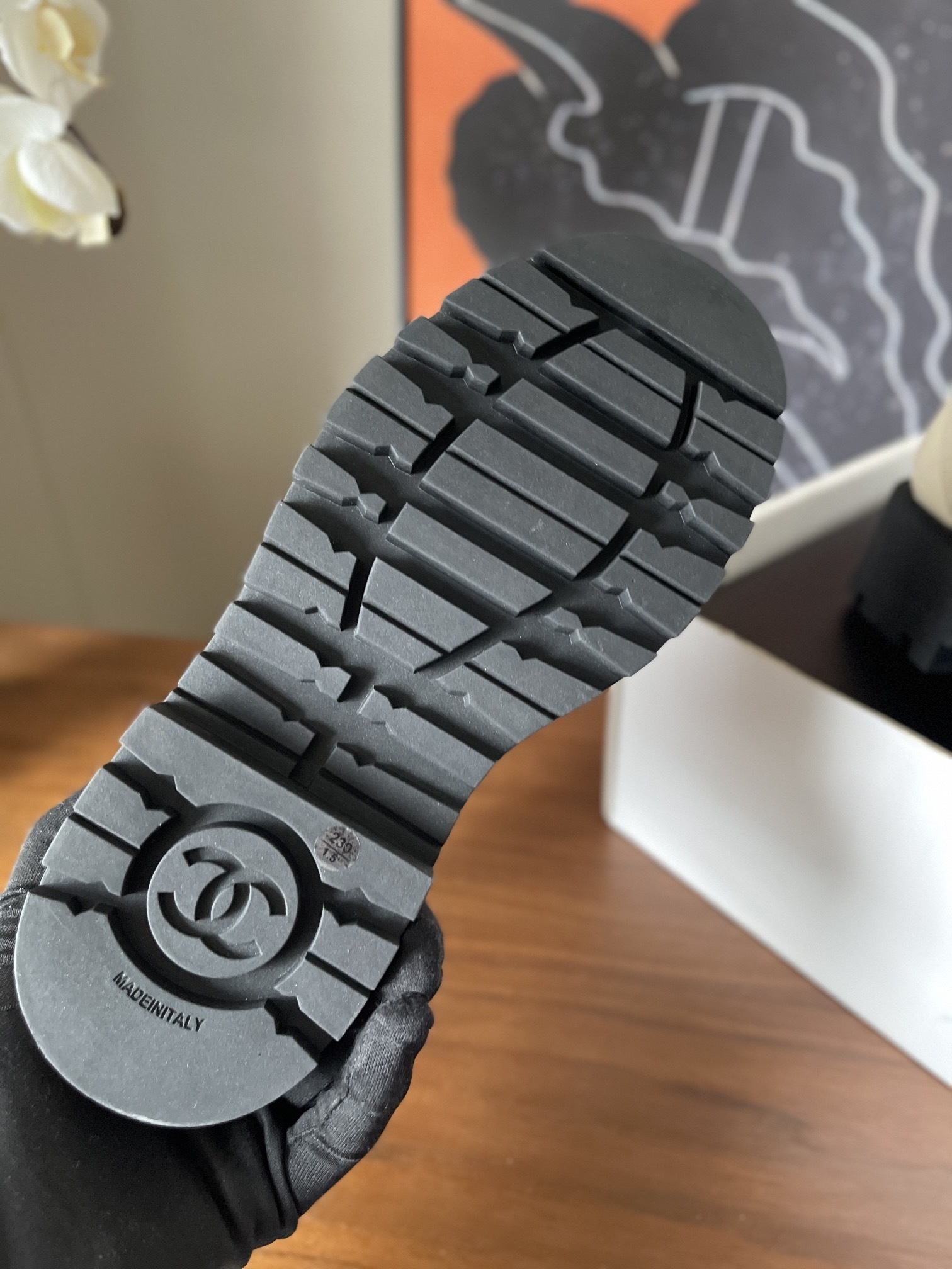 Pair of luxury quilted beige leather combat boots with black toe caps and chunky platform soles displayed on a wooden surface. - Hình 9