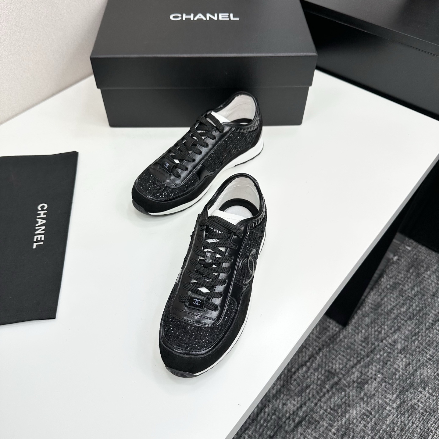Side view of Chanel black sneakers with tweed and suede details on a black box - Hình 5