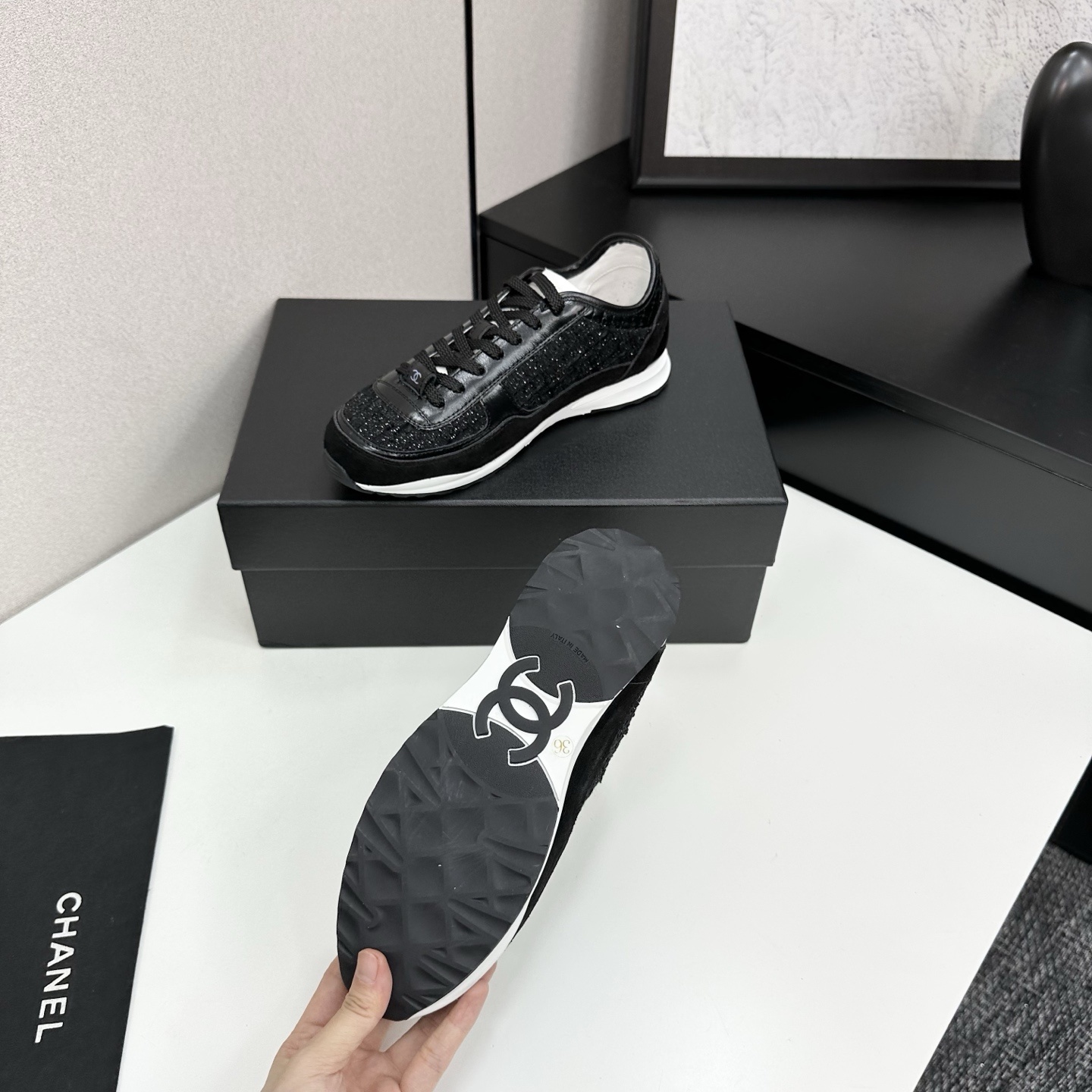 Side view of Chanel black sneakers with tweed and suede details on a black box - Hình 4