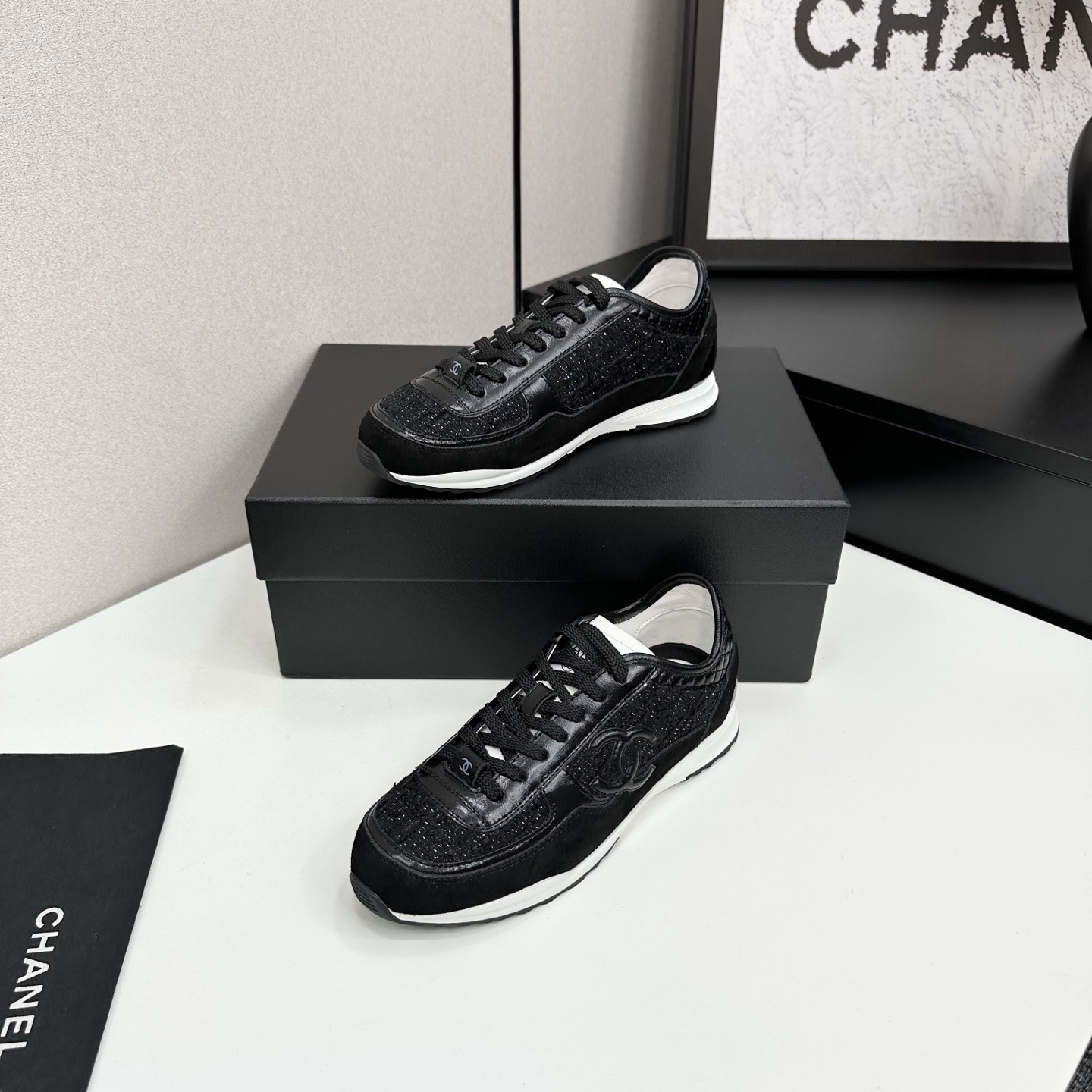 Side view of Chanel black sneakers with tweed and suede details on a black box - Hình 2