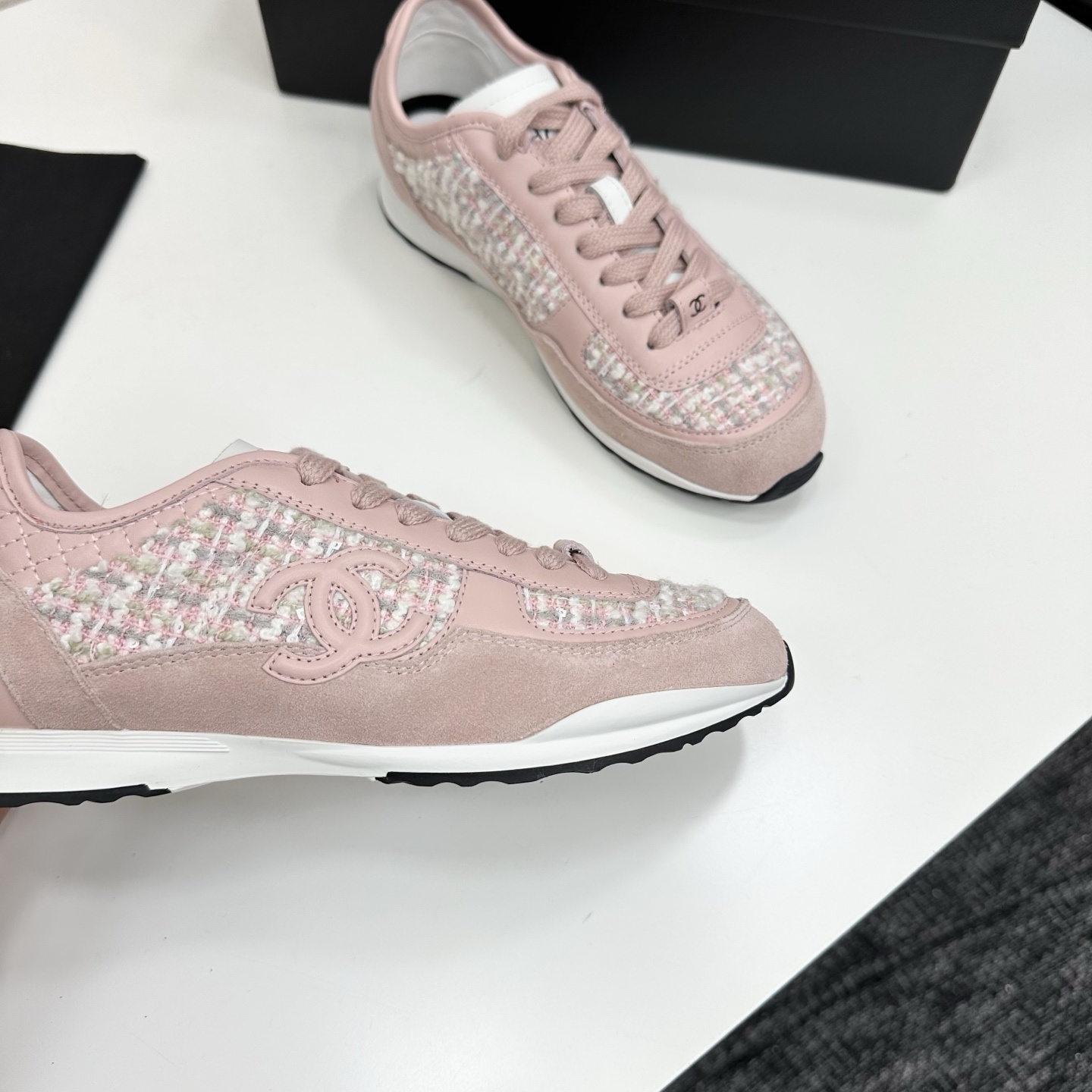 Side view of luxury blush pink sneakers featuring tweed fabric panels and interlocking logo on a black box. - Hình 9