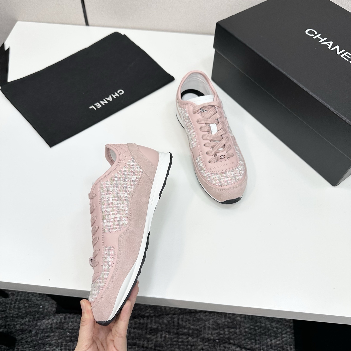 Side view of luxury blush pink sneakers featuring tweed fabric panels and interlocking logo on a black box. - Hình 8