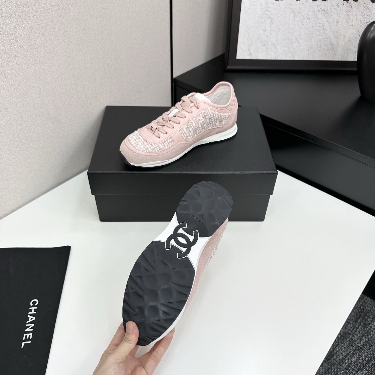 Side view of luxury blush pink sneakers featuring tweed fabric panels and interlocking logo on a black box. - Hình 4