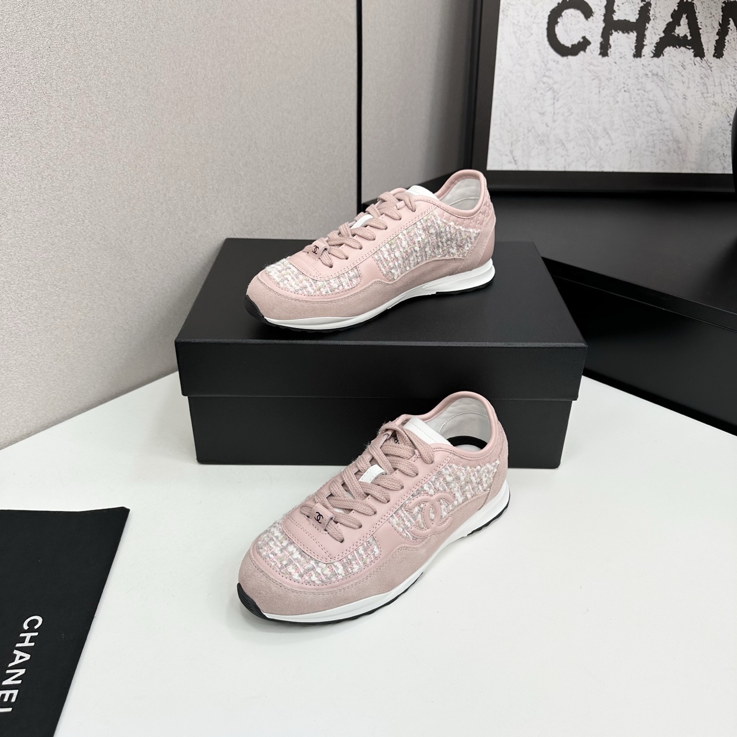 Side view of luxury blush pink sneakers featuring tweed fabric panels and interlocking logo on a black box. - Hình 2