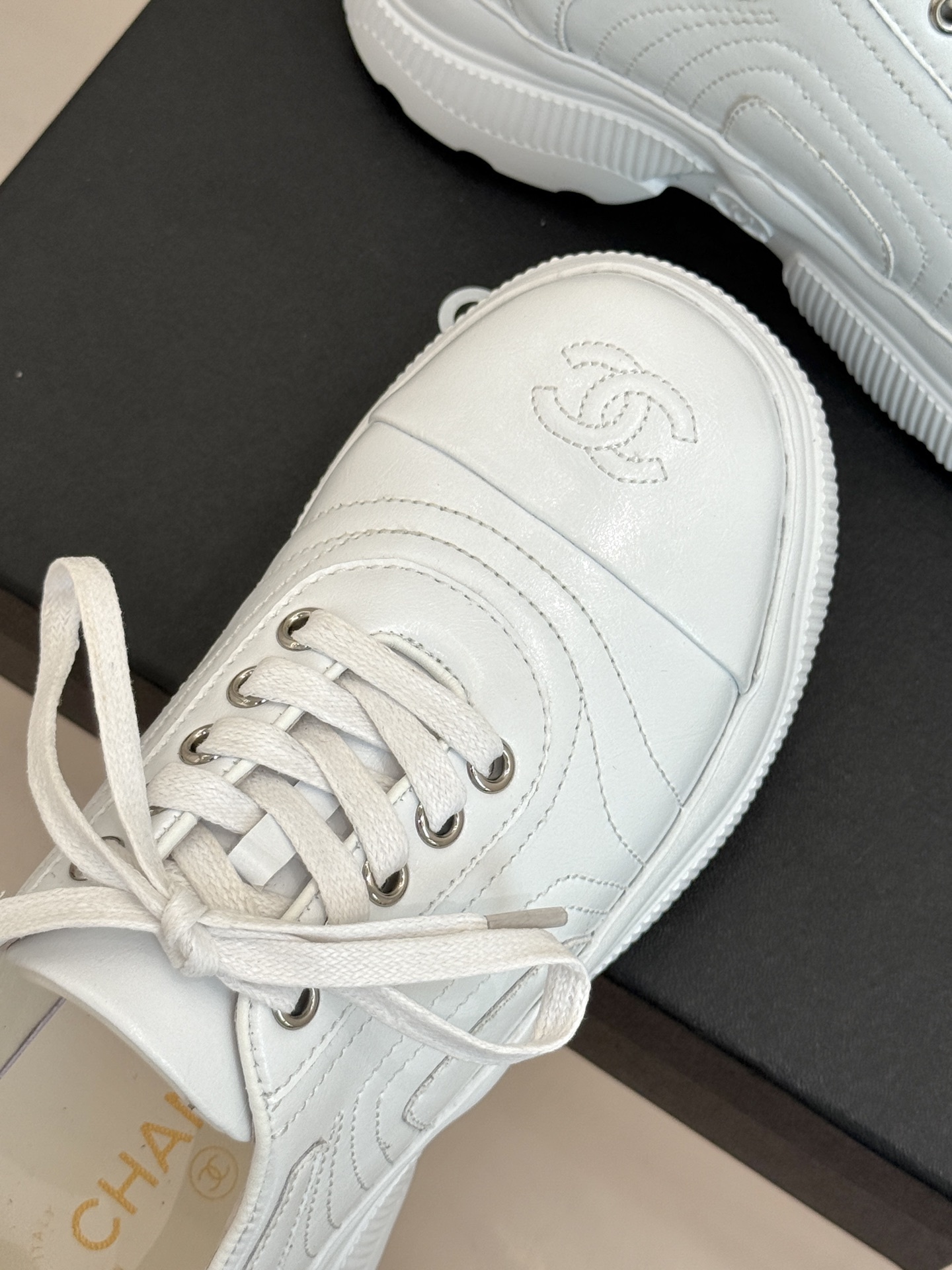 A pair of luxury white leather platform sneakers with embossed logo sitting on a black box. - Hình 7