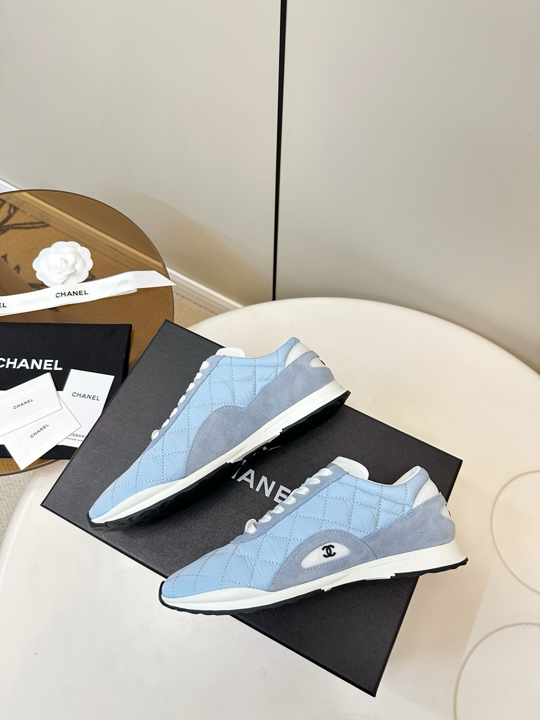 Luxury Chanel light blue quilted fabric and suede sneakers with white laces and CC logo on a black designer box. - Hình 9