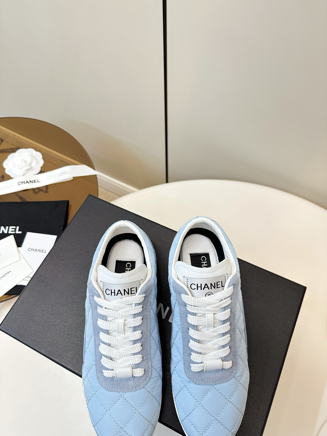 Luxury Chanel light blue quilted fabric and suede sneakers with white laces and CC logo on a black designer box. - Hình 8