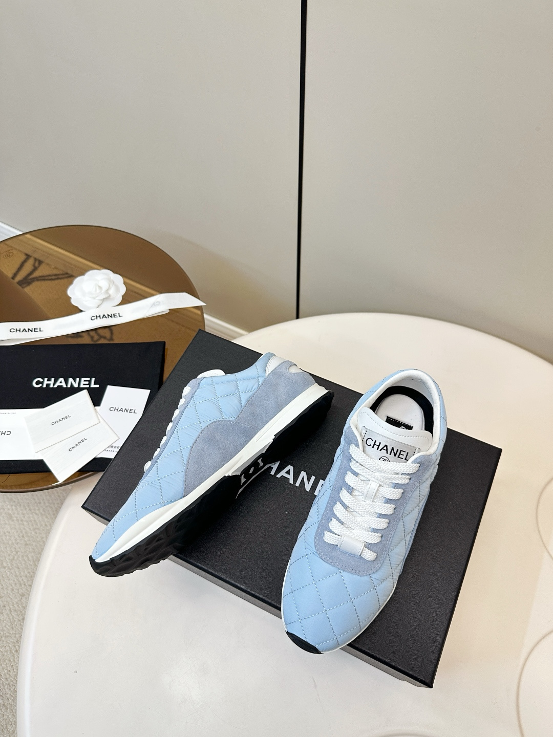 Luxury Chanel light blue quilted fabric and suede sneakers with white laces and CC logo on a black designer box. - Hình 5