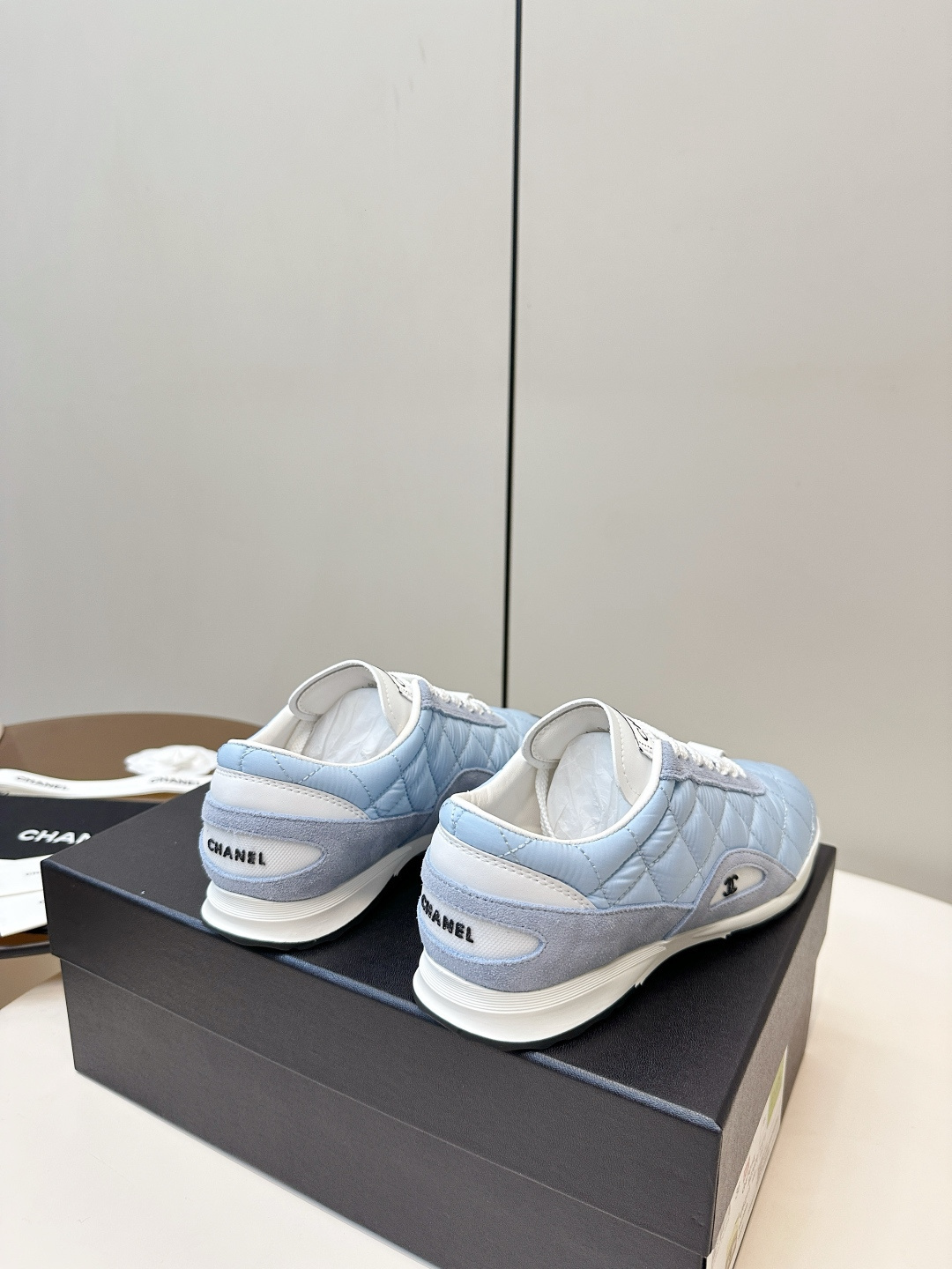 Luxury Chanel light blue quilted fabric and suede sneakers with white laces and CC logo on a black designer box. - Hình 4