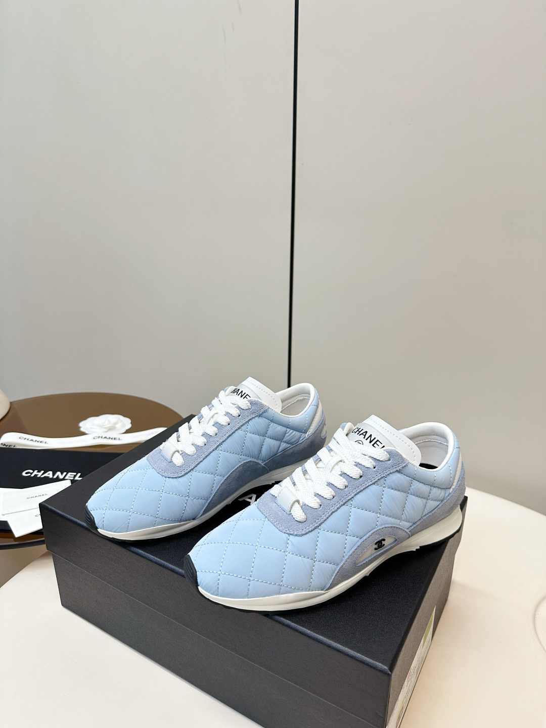Luxury Chanel light blue quilted fabric and suede sneakers with white laces and CC logo on a black designer box. - Hình 3