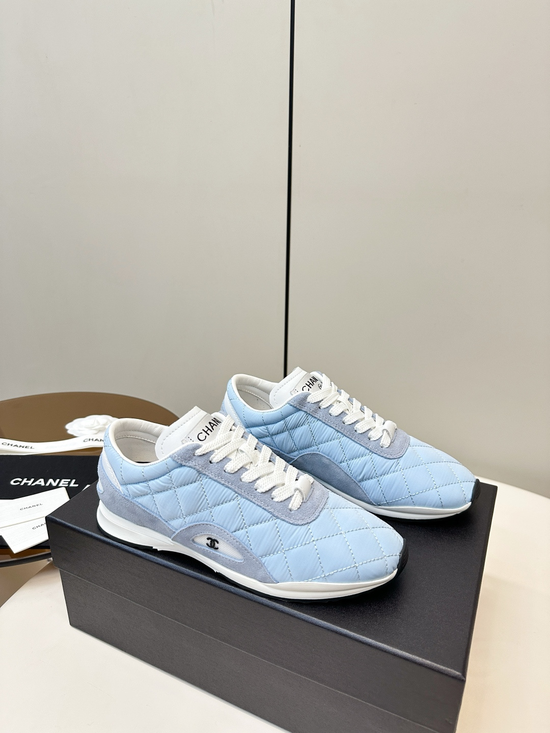 Luxury Chanel light blue quilted fabric and suede sneakers with white laces and CC logo on a black designer box. - Hình 2