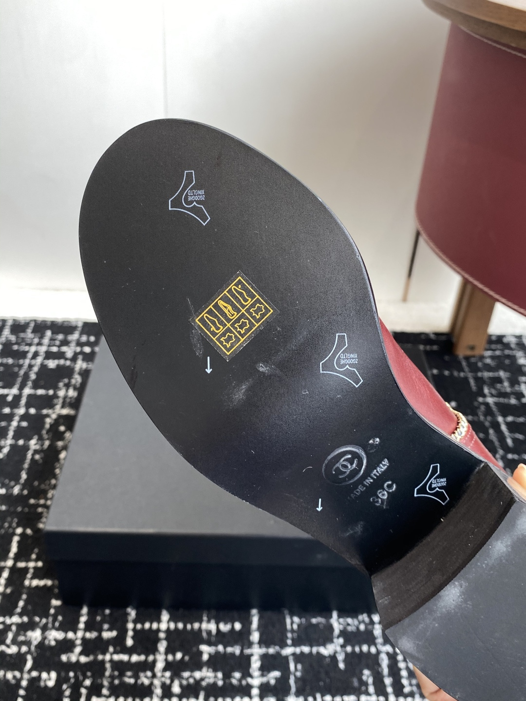 Luxurious Chanel burgundy leather knee-high boots with gold chain trim and black cap-toes displayed on a black box. - Hình 9