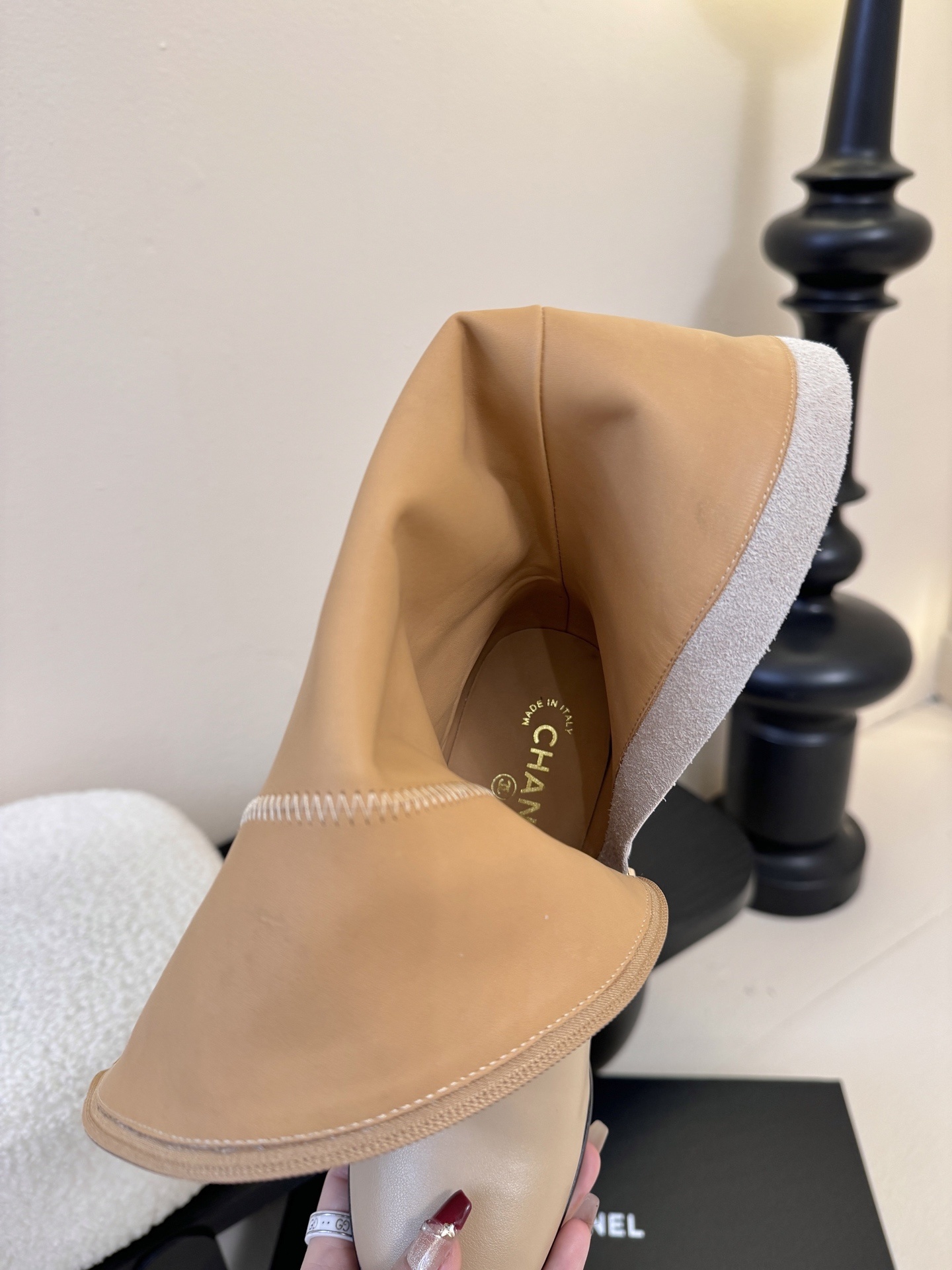 Luxury Chanel white leather knee-high boots decorated with gold-tone CC logos and charms on a display stand. - Hình 8