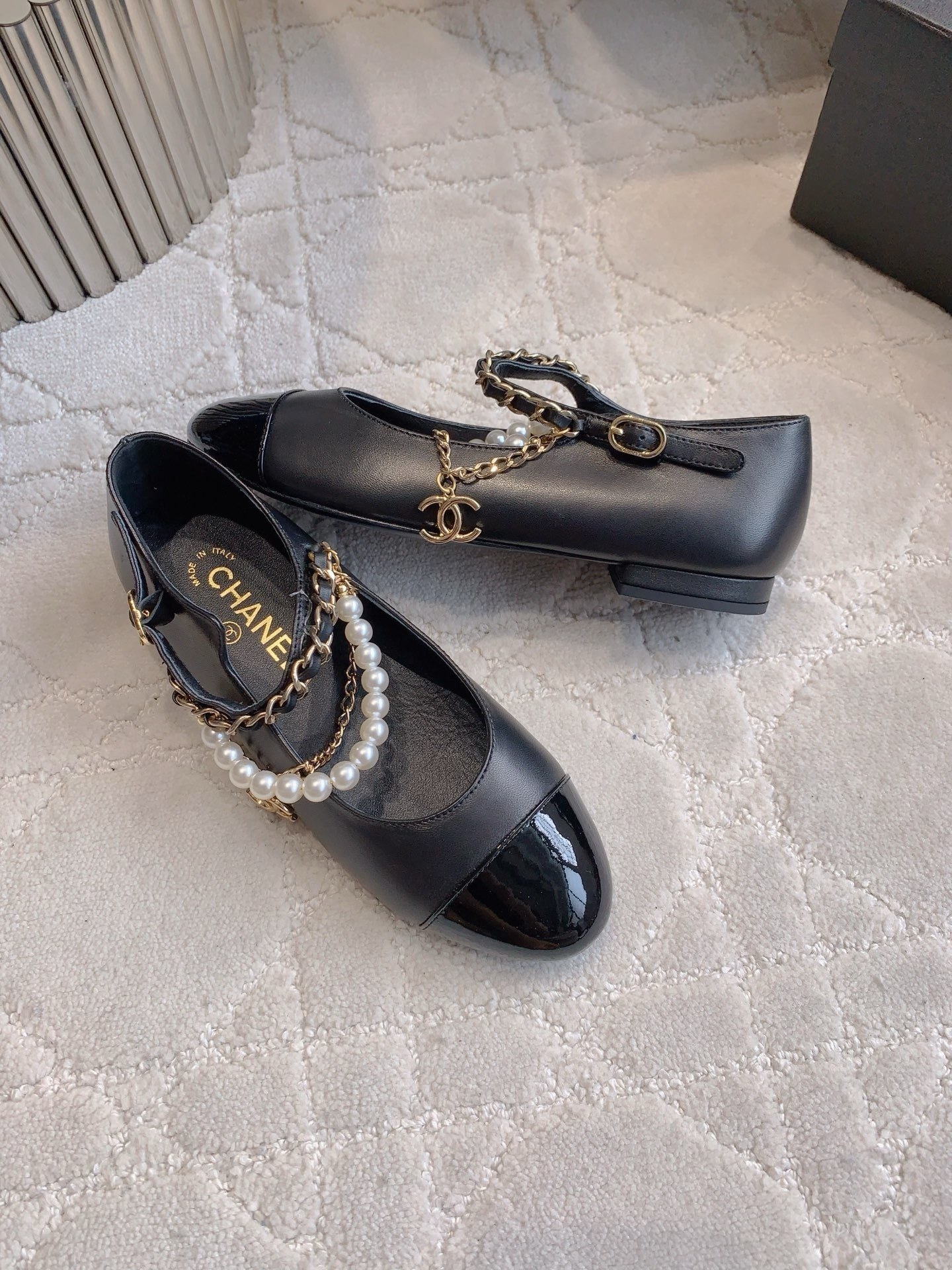 Luxury Chanel black leather Mary Jane flats with patent toe and pearl chain embellishments. - Hình 4