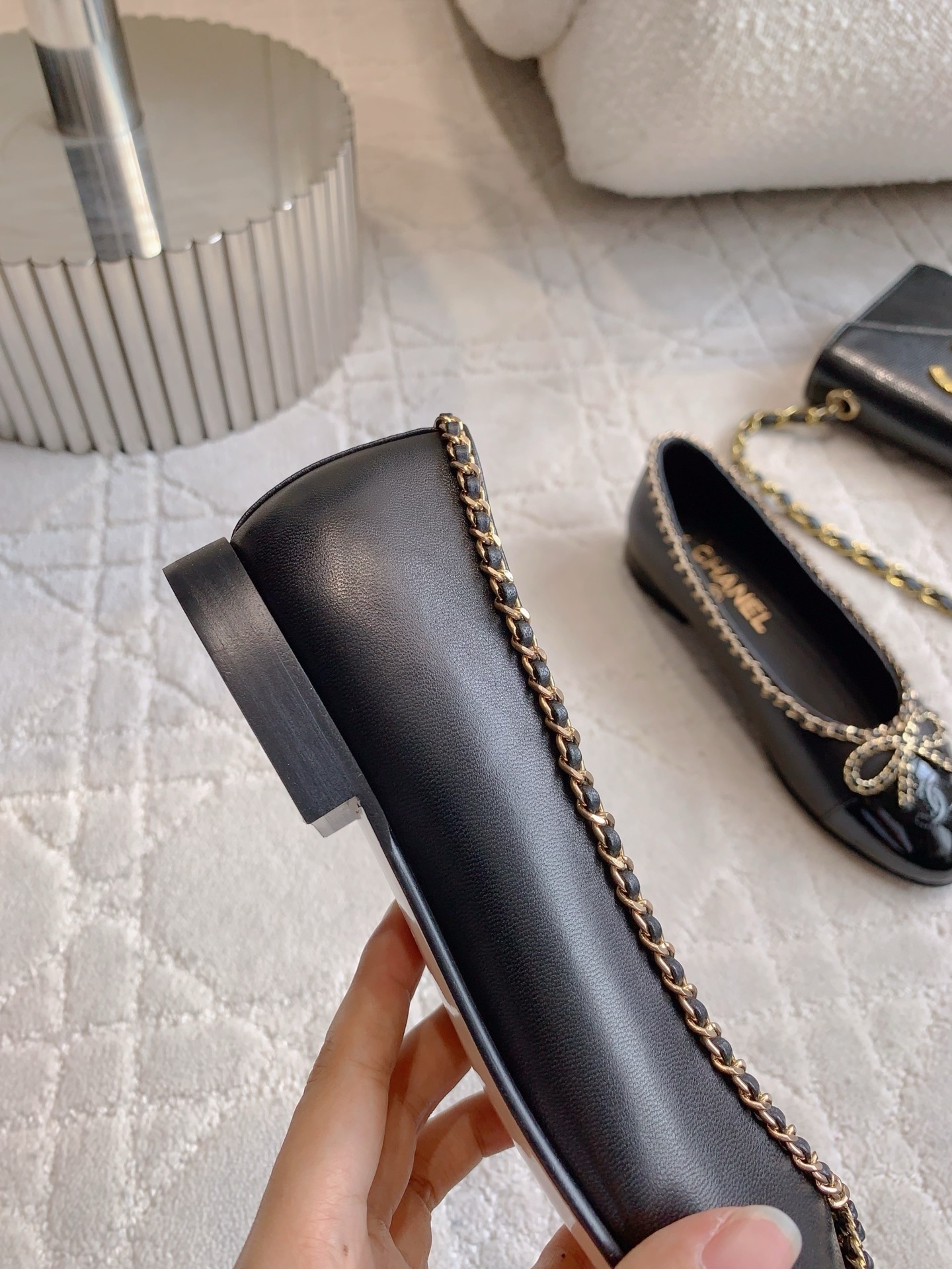 Pair of Chanel black leather ballerina flats with gold chain trim and patent leather toe cap on a marble table - Hình 9