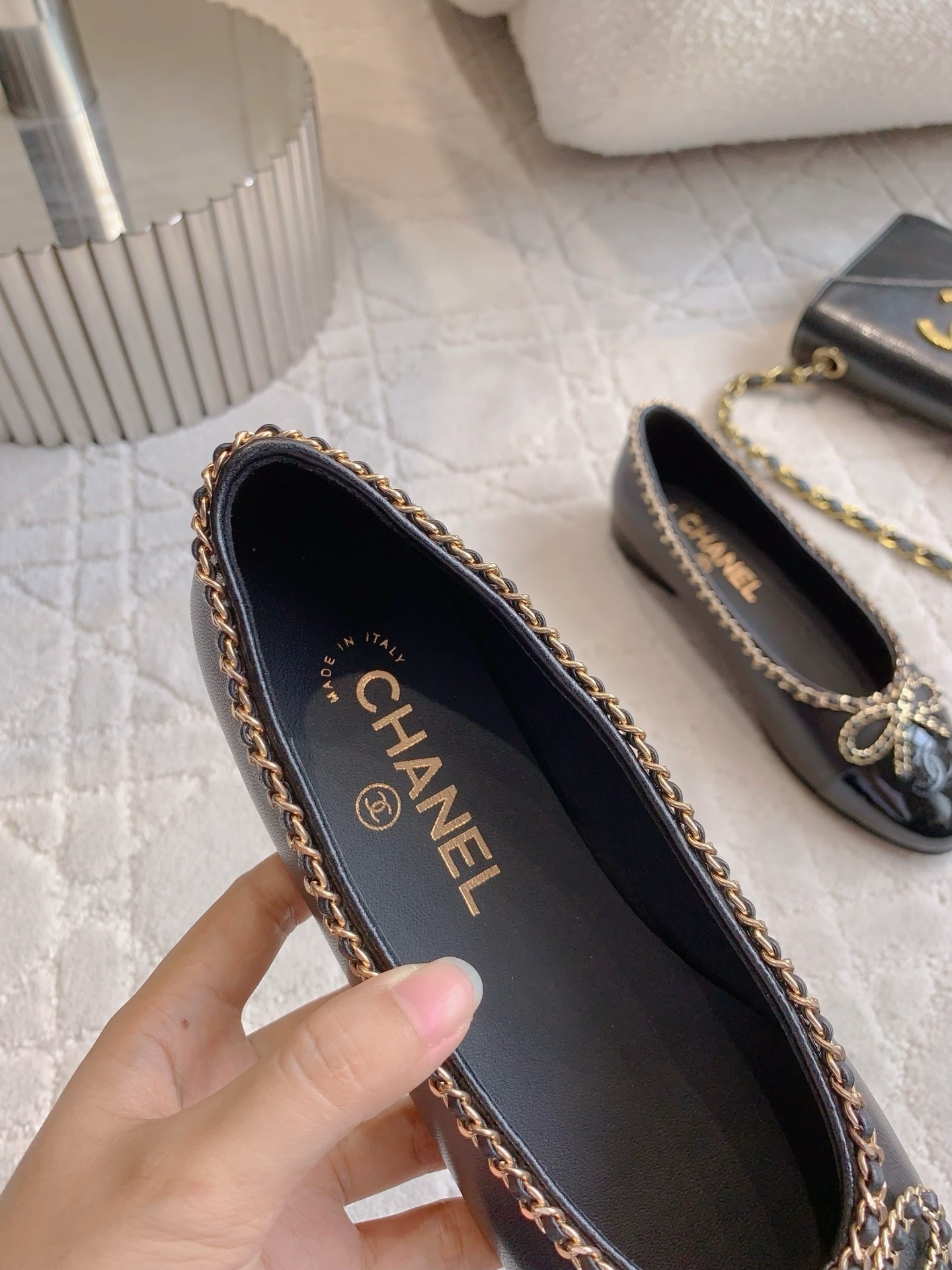 Pair of Chanel black leather ballerina flats with gold chain trim and patent leather toe cap on a marble table - Hình 8