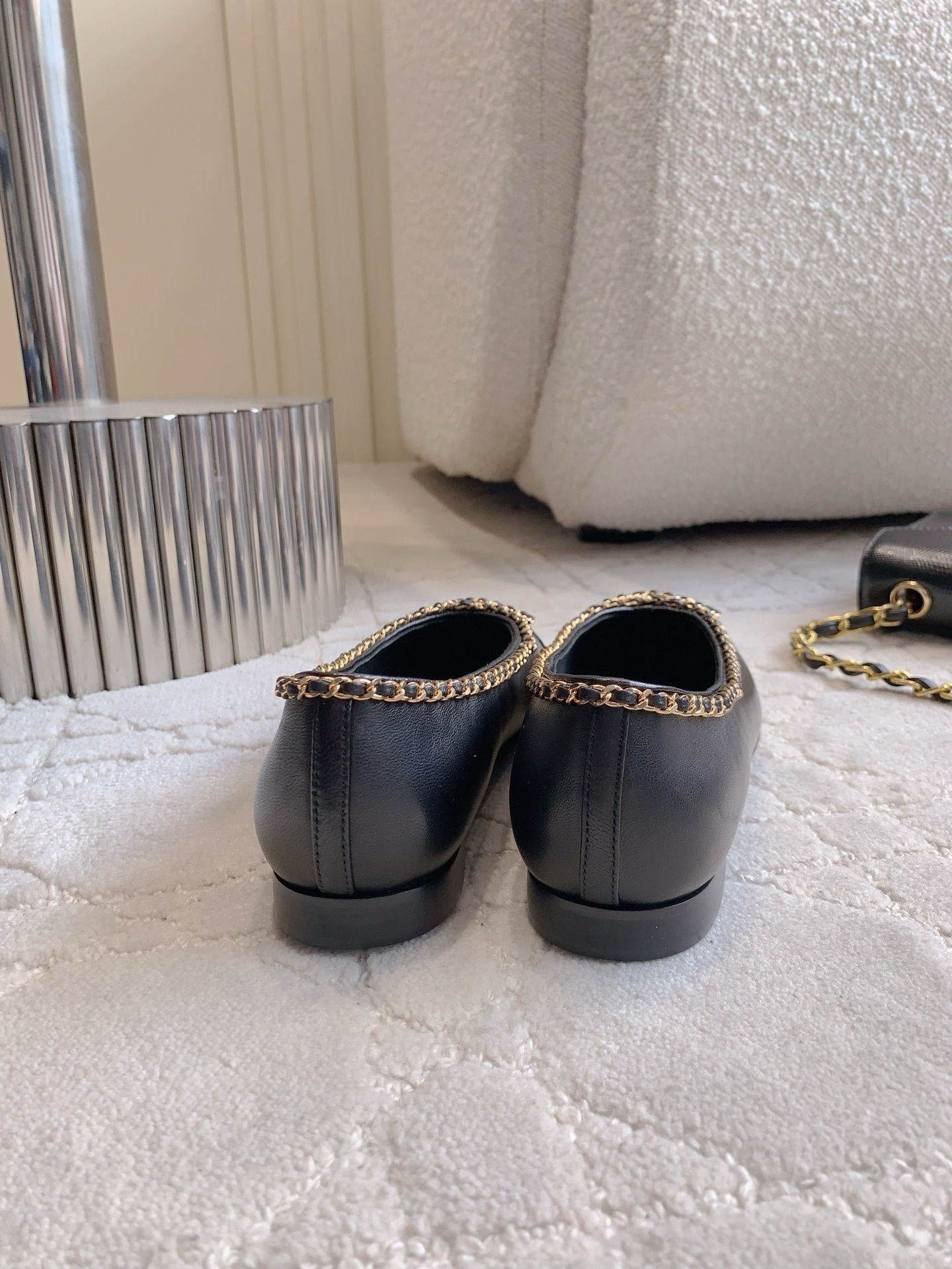Pair of Chanel black leather ballerina flats with gold chain trim and patent leather toe cap on a marble table - Hình 5