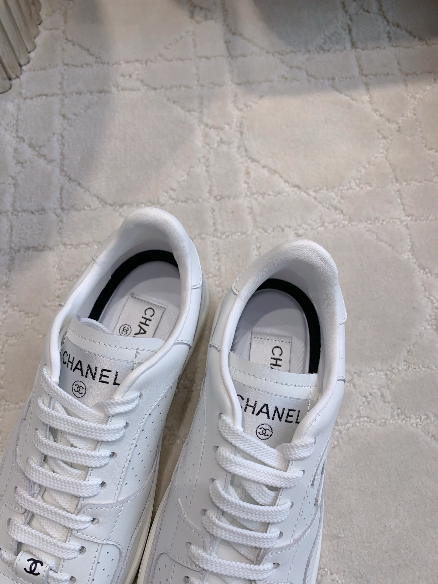 Pair of premium white Chanel calfskin leather sneakers with CC logo and perforated detailing. - Hình 6