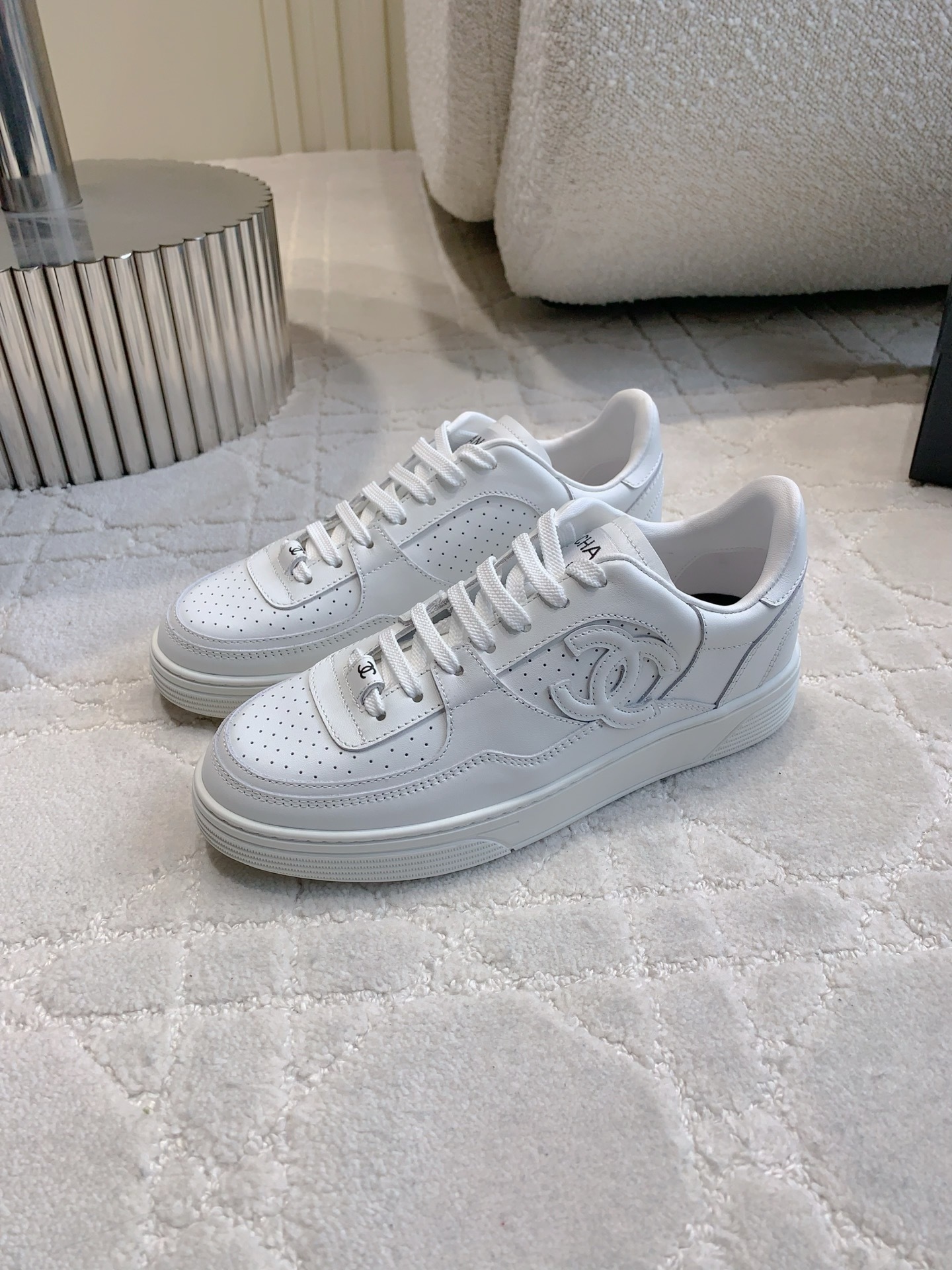 Pair of premium white Chanel calfskin leather sneakers with CC logo and perforated detailing. - Hình 2