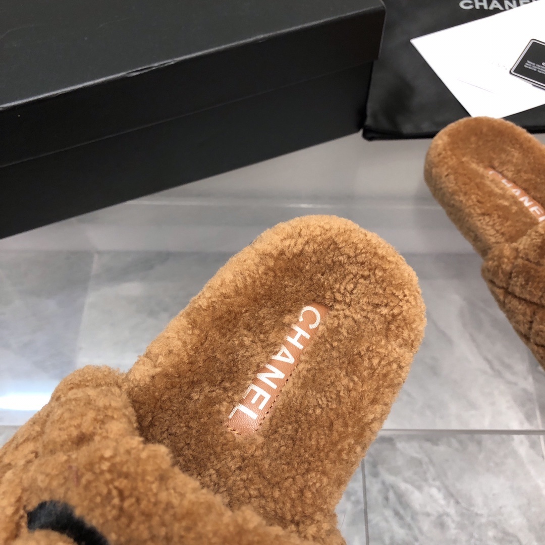A pair of luxury Chanel brown quilted shearling slides with a black CC logo, shown with original packaging and authenticity card. - Hình 5