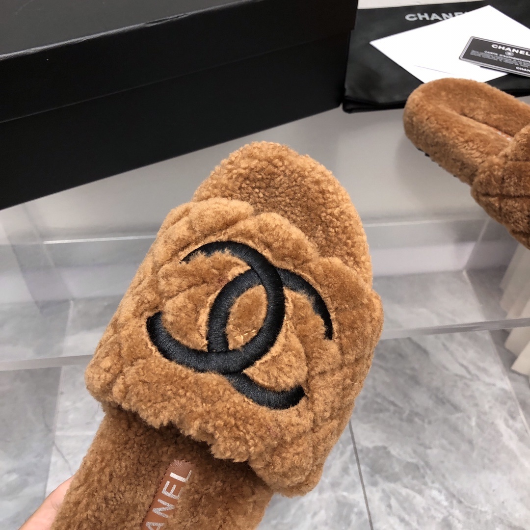 A pair of luxury Chanel brown quilted shearling slides with a black CC logo, shown with original packaging and authenticity card. - Hình 4