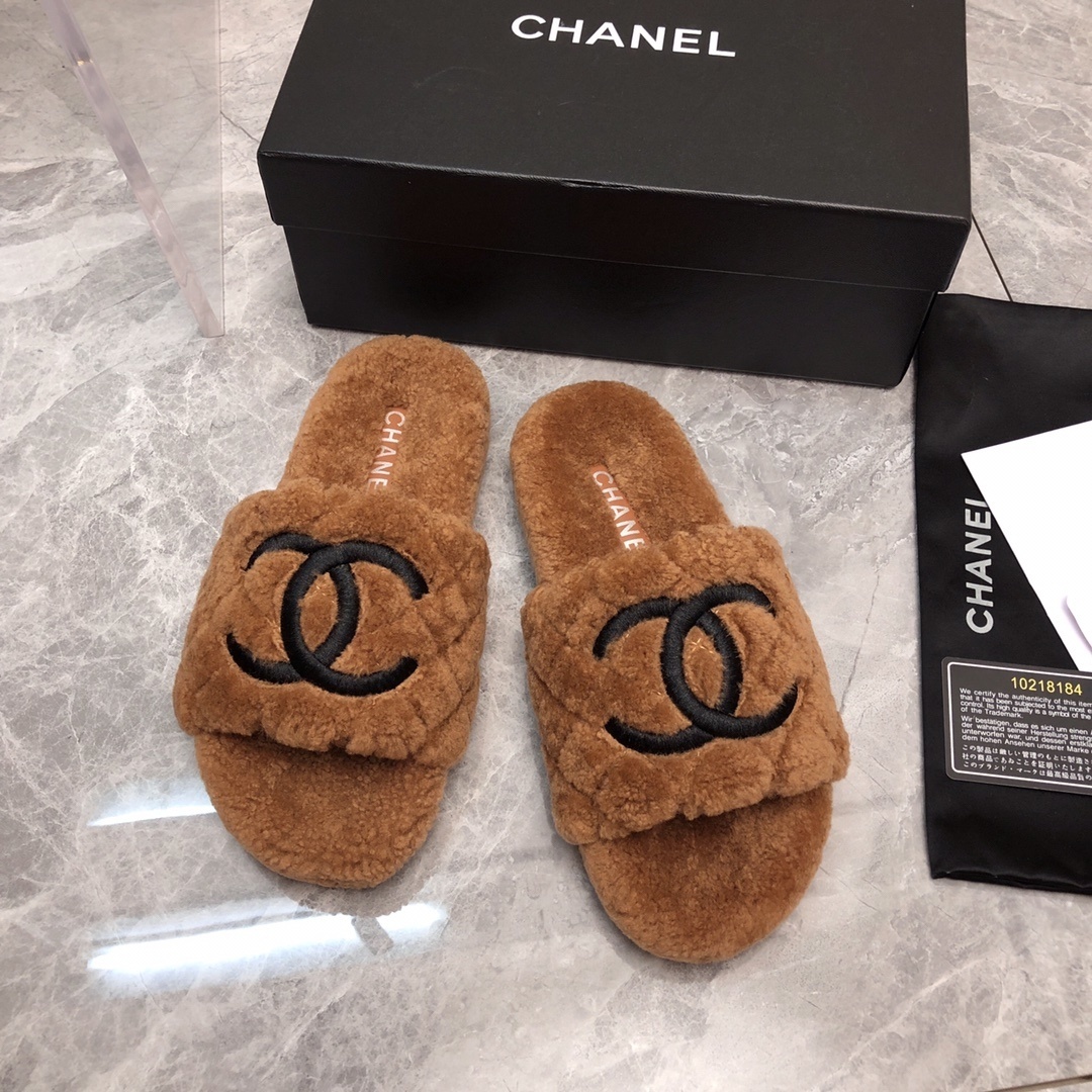 A pair of luxury Chanel brown quilted shearling slides with a black CC logo, shown with original packaging and authenticity card. - Hình 2