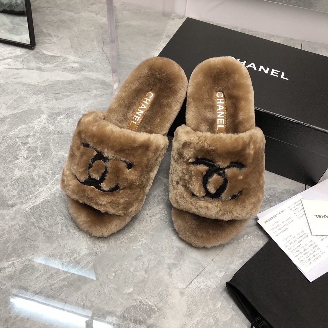 A pair of luxury tan Chanel shearling fur slides with black CC logo, displayed with original box and authenticity card. - Hình 9