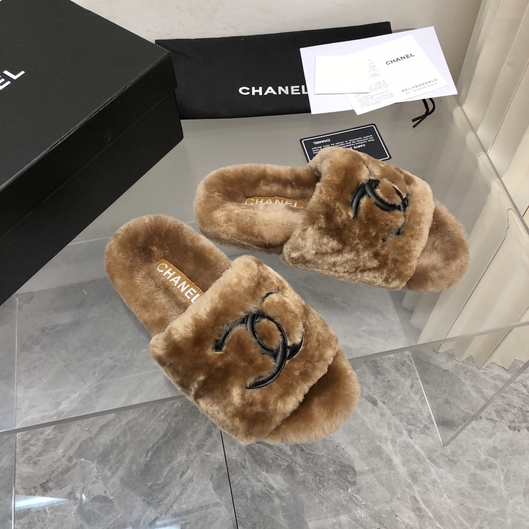 A pair of luxury tan Chanel shearling fur slides with black CC logo, displayed with original box and authenticity card. - Hình 7