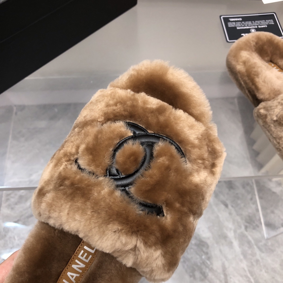 A pair of luxury tan Chanel shearling fur slides with black CC logo, displayed with original box and authenticity card. - Hình 4