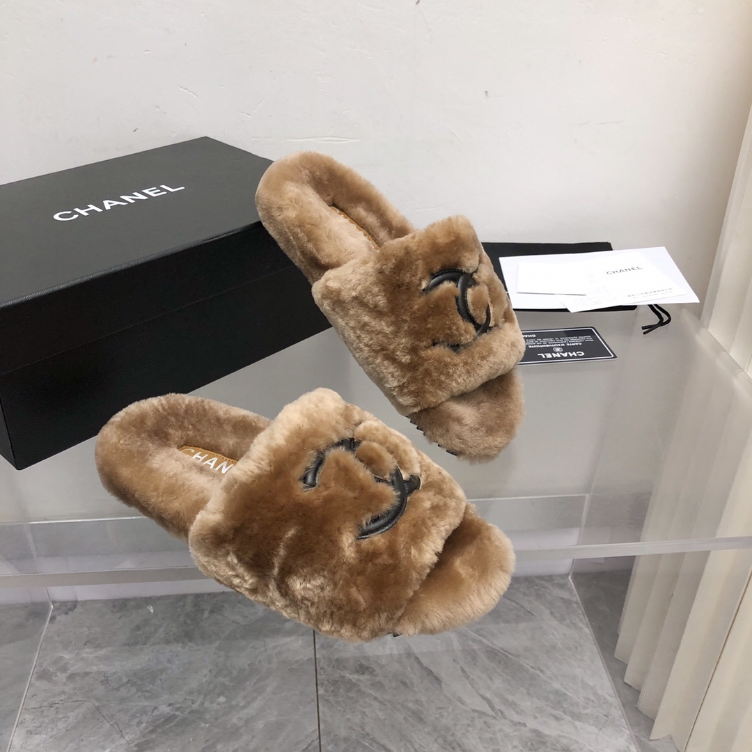 A pair of luxury tan Chanel shearling fur slides with black CC logo, displayed with original box and authenticity card. - Hình 3