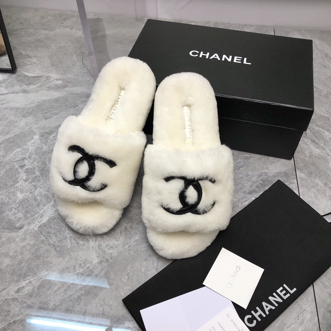Pair of luxury white plush fur slippers with a black interlocking logo displayed with designer packaging. - Hình 9