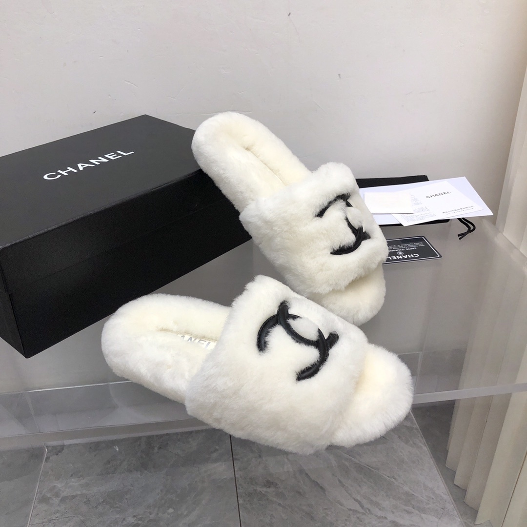 Pair of luxury white plush fur slippers with a black interlocking logo displayed with designer packaging. - Hình 7