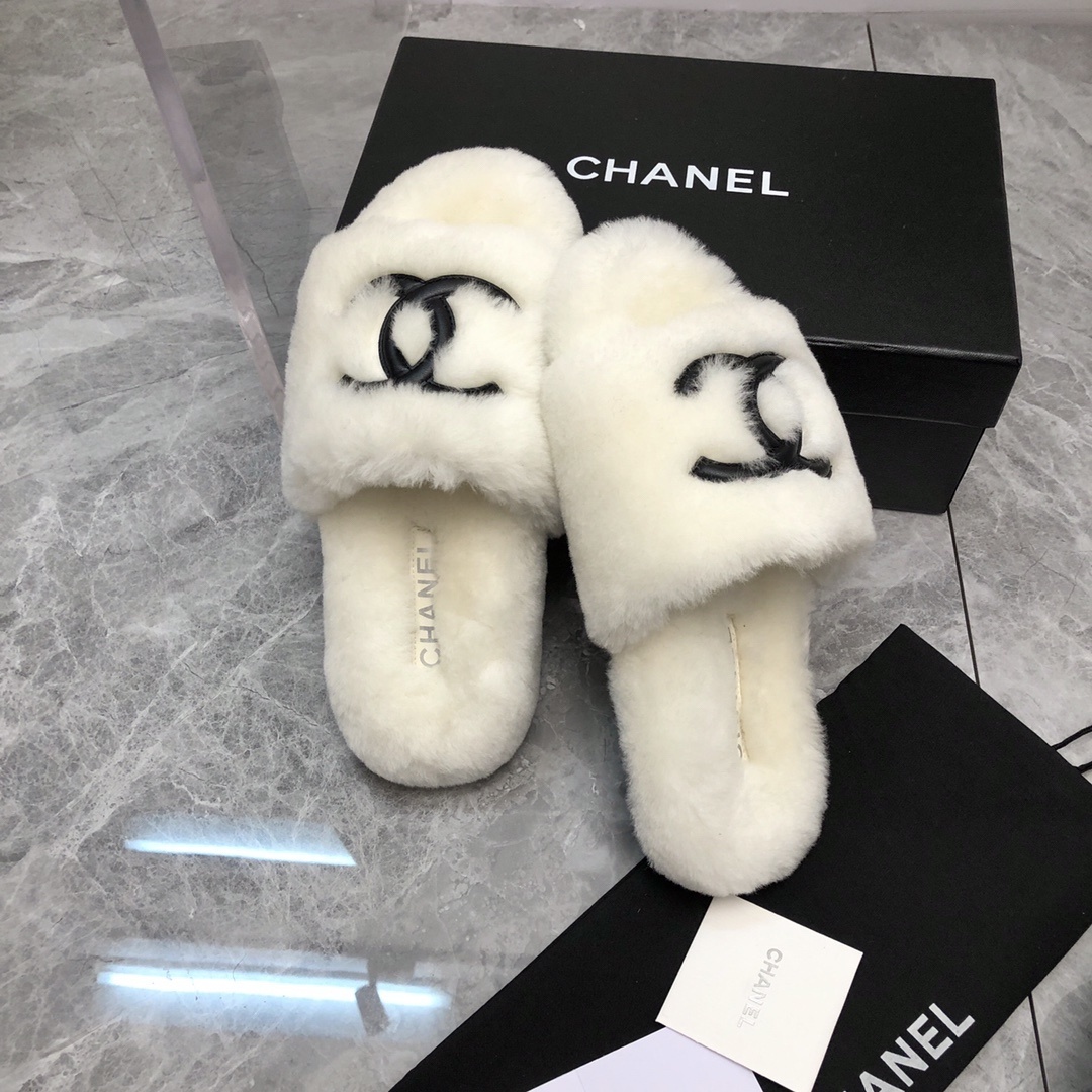 Pair of luxury white plush fur slippers with a black interlocking logo displayed with designer packaging. - Hình 6