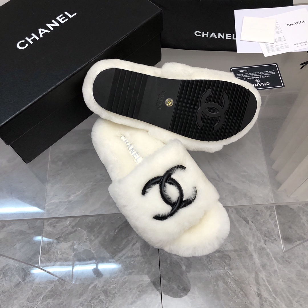 Pair of luxury white plush fur slippers with a black interlocking logo displayed with designer packaging. - Hình 5
