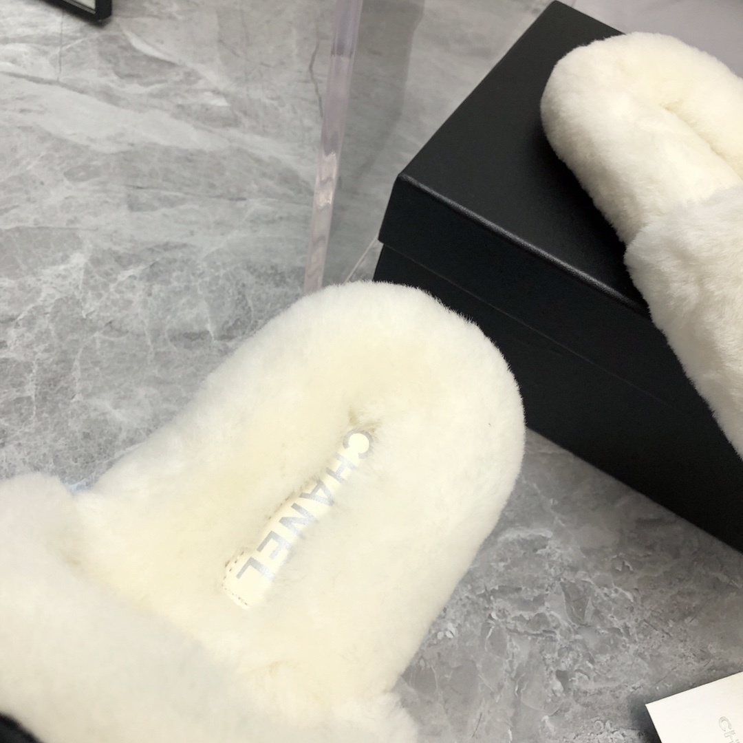 Pair of luxury white plush fur slippers with a black interlocking logo displayed with designer packaging. - Hình 4