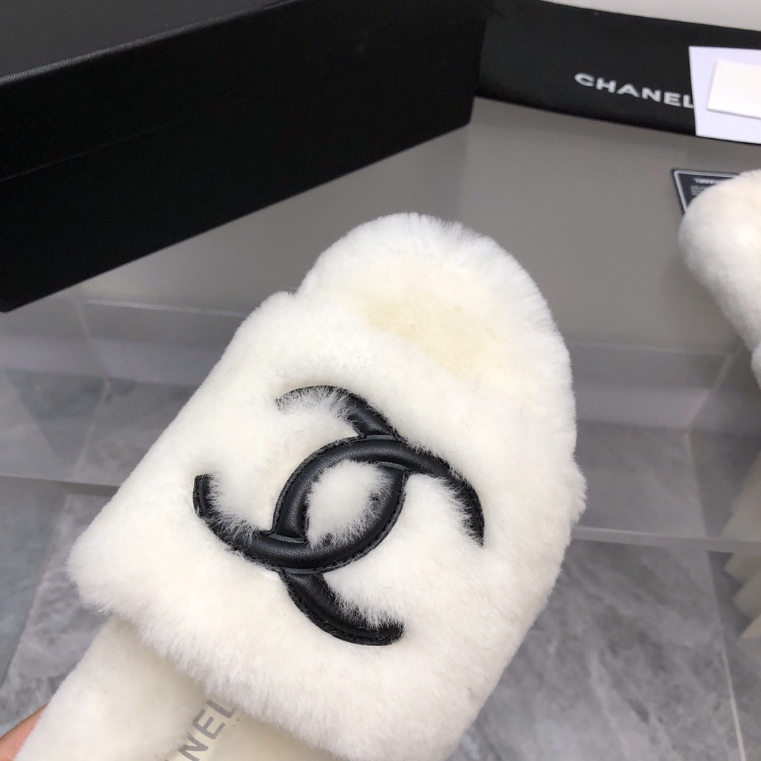 Pair of luxury white plush fur slippers with a black interlocking logo displayed with designer packaging. - Hình 3