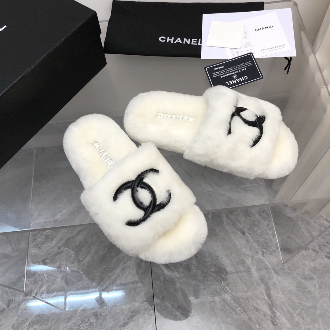 Pair of luxury white plush fur slippers with a black interlocking logo displayed with designer packaging. - Hình 2